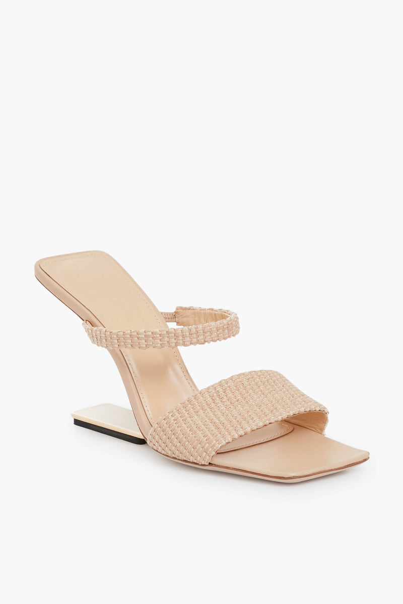 The Cult Gaia beige sandal features a geometric heel, square toe, and two woven straps.