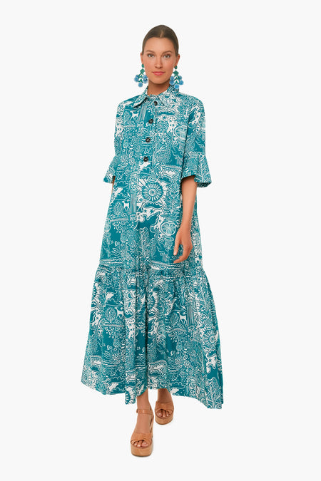 A woman wears the La DoubleJ Ionic Artemis Dress, a teal and white cotton poplin maxi with ruffled sleeves and hem, styled with statement earrings and tan platform sandals.