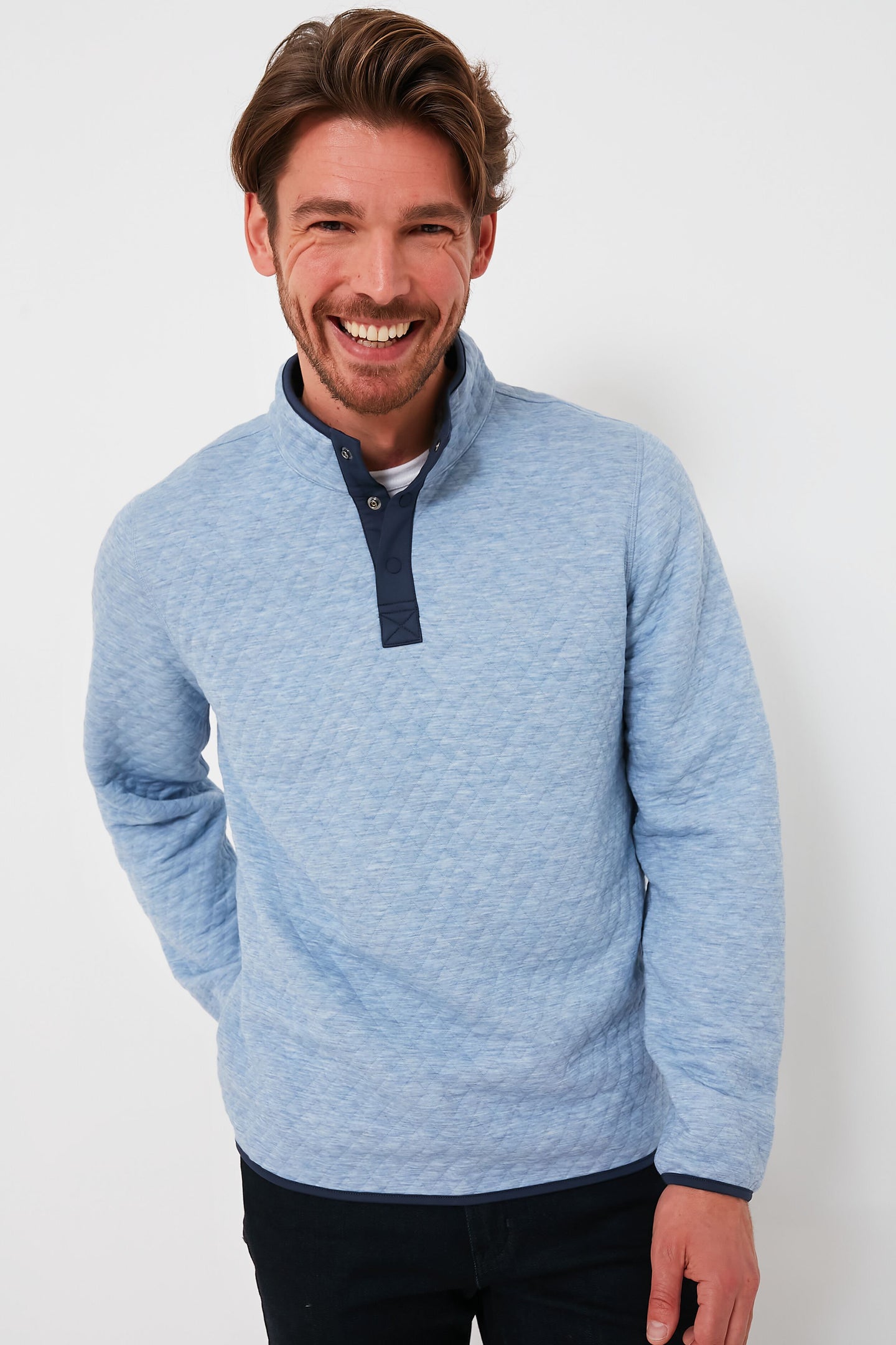 A man with light brown hair and a beard smiles at the camera, wearing a super soft, reversible Marine Layer pullover with a dark collar.