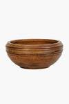The Juliska mango wood serving bowl features a round, shallow design with a smooth finish and subtle horizontal grooves near the rim, offering an artisanal touch.
