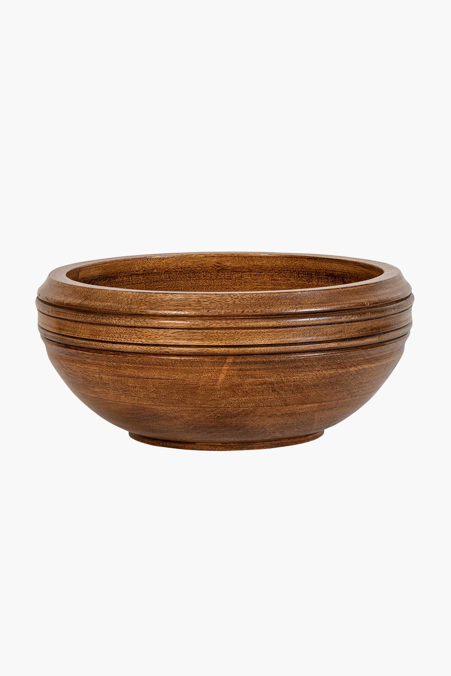 The Juliska mango wood serving bowl features a round, shallow design with a smooth finish and subtle horizontal grooves near the rim, offering an artisanal touch.