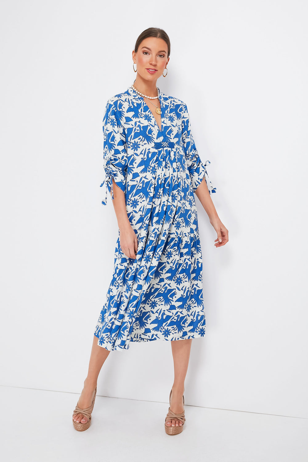 Woman wearing a Nimo With Love blue and white floral Catmint Dress with 3/4 sleeves, tan heeled sandals, and a beaded neckline.
