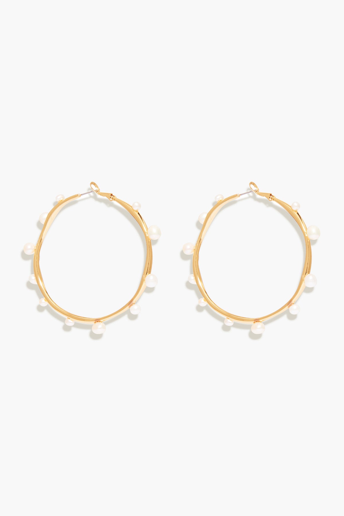 Mignonne Gavigan's Isla Pearl Hoops are gold-plated earrings accented with small, evenly spaced freshwater pearls around each hoop.