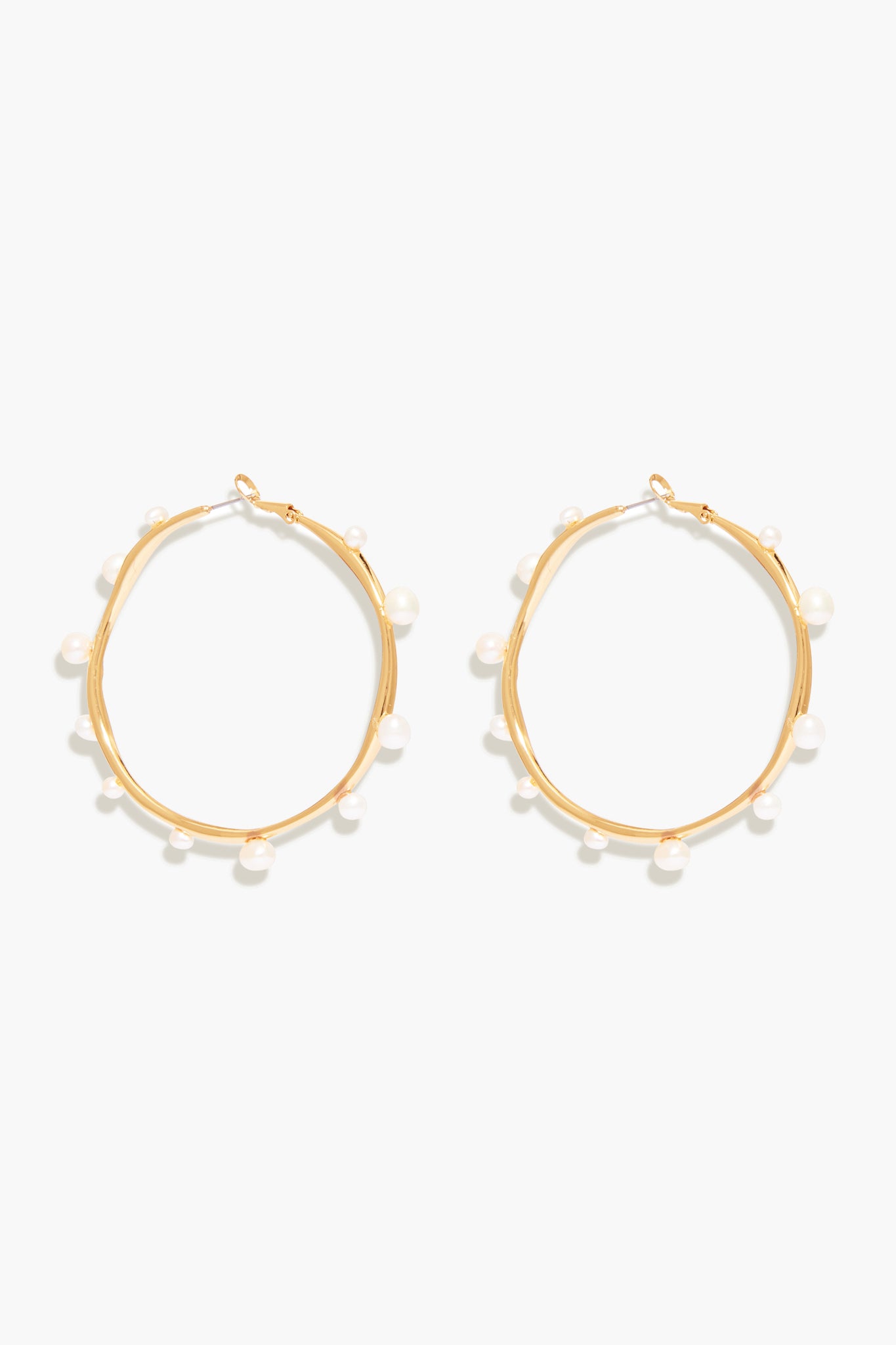 Mignonne Gavigan's Isla Pearl Hoops are gold-plated earrings accented with small, evenly spaced freshwater pearls around each hoop.