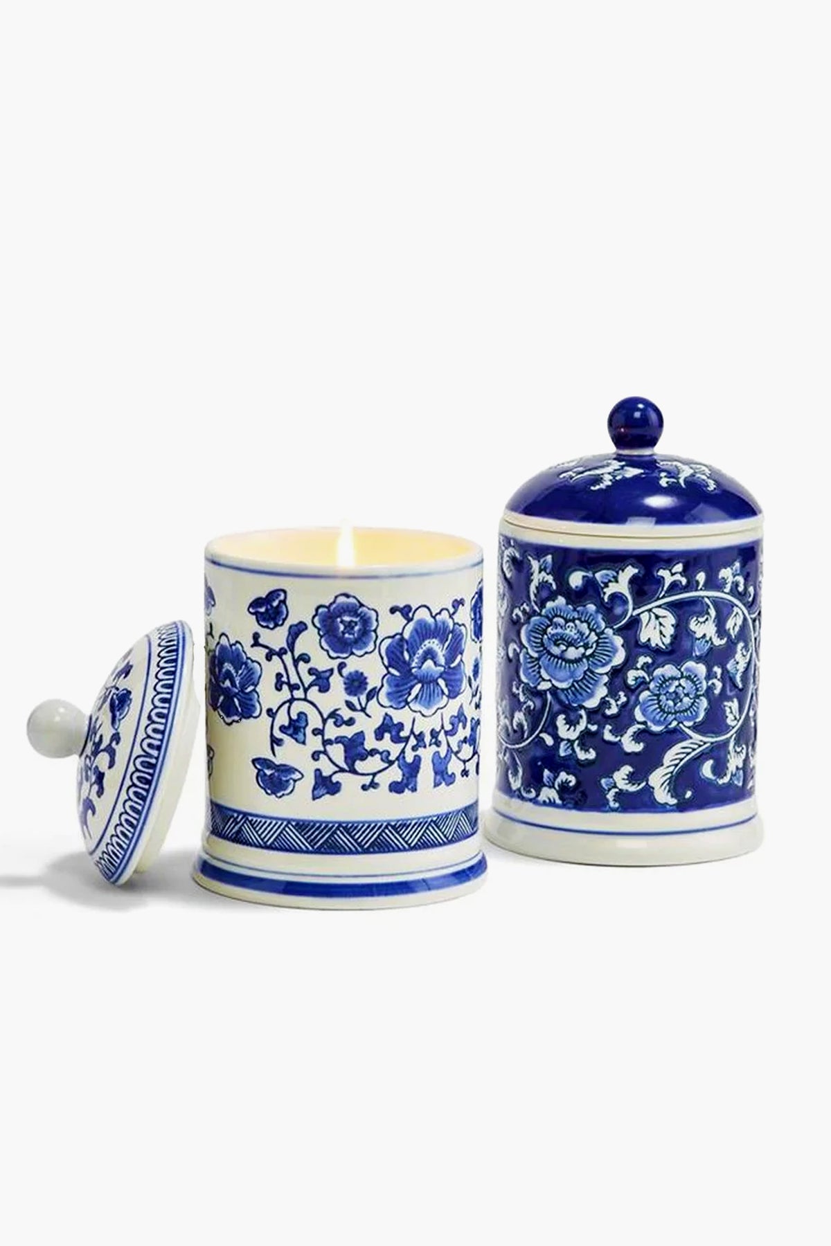 Two's Company Canton Collection offers two decorative ceramic jars with blue floral designs: one holds a fresh linen scented candle with the lid off, while the other jar has its lid on.
