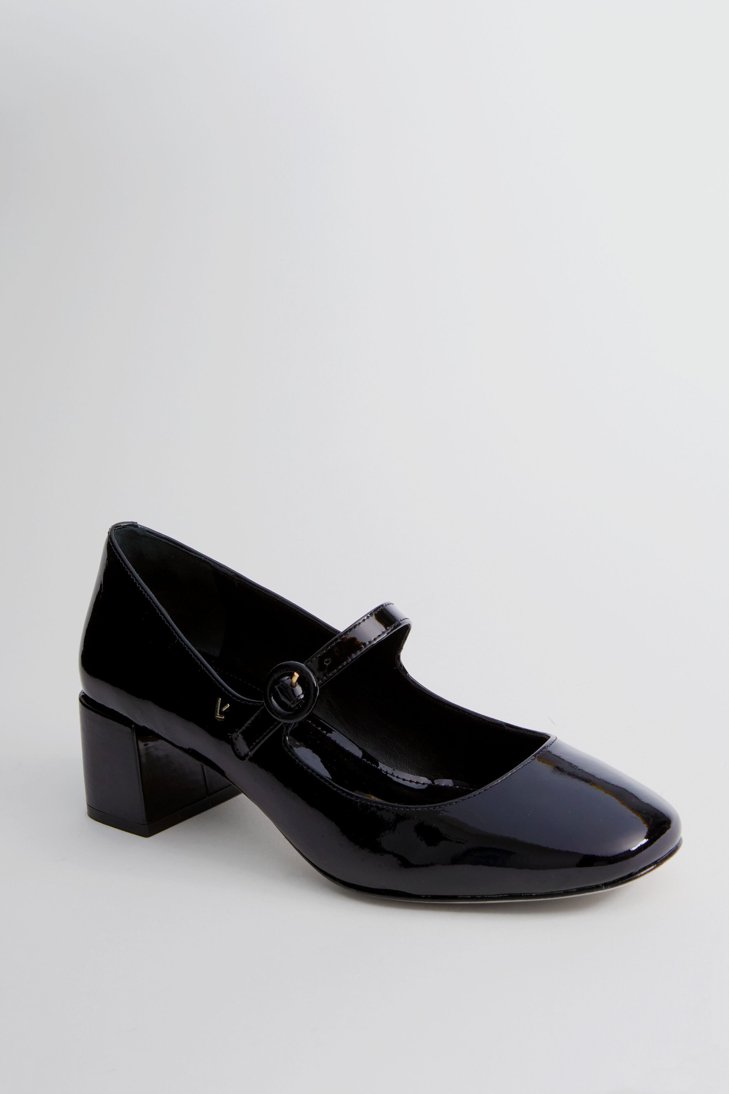 Larroude black patent leather Mary Jane pumps feature a low block heel and a single strap with a round buckle.