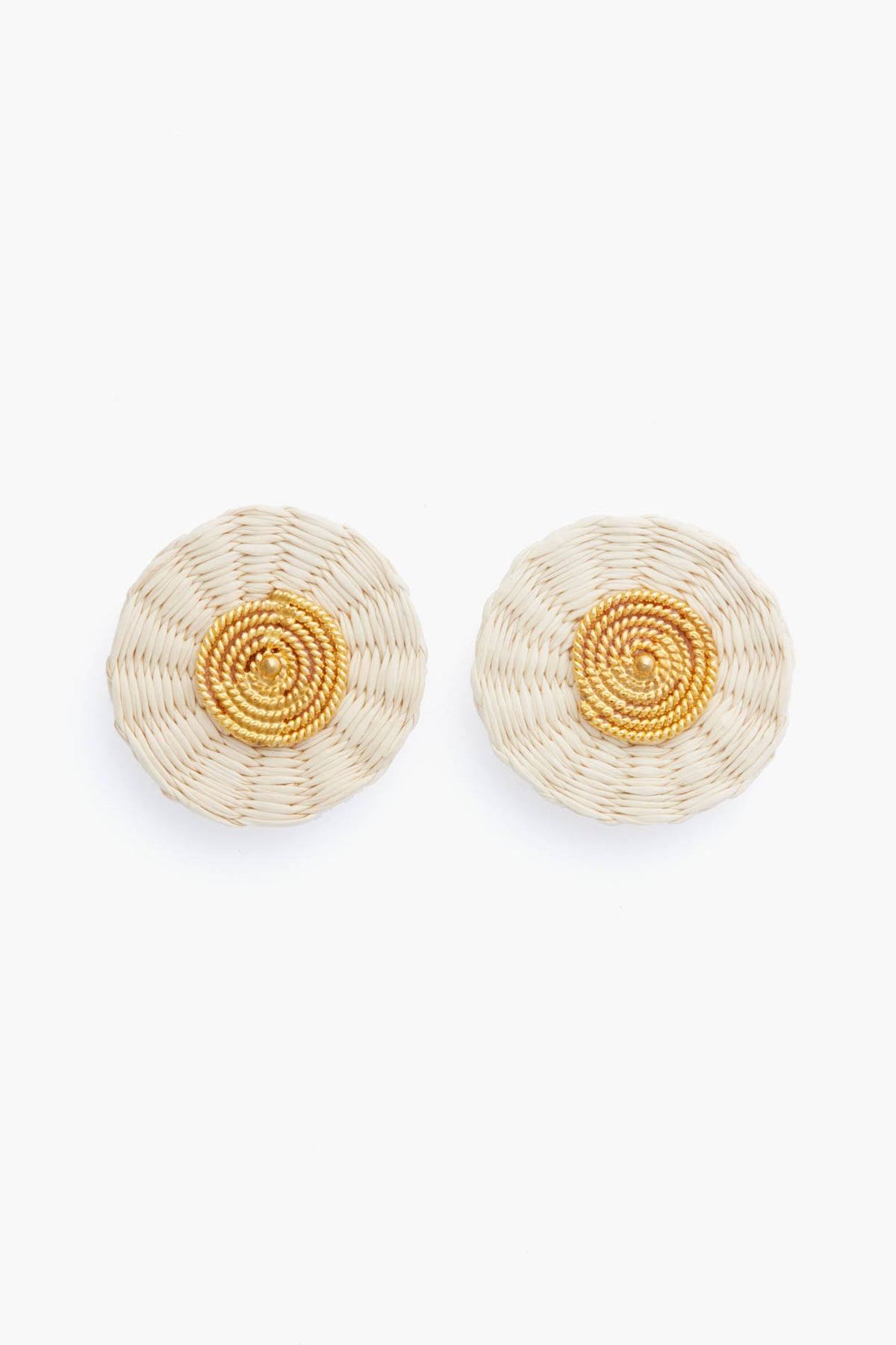 Ana Carolina Valencia presents handmade round woven earrings in beige and gold tones with a concentric pattern, finished with gold-plated studs for a modern jewelry touch.
