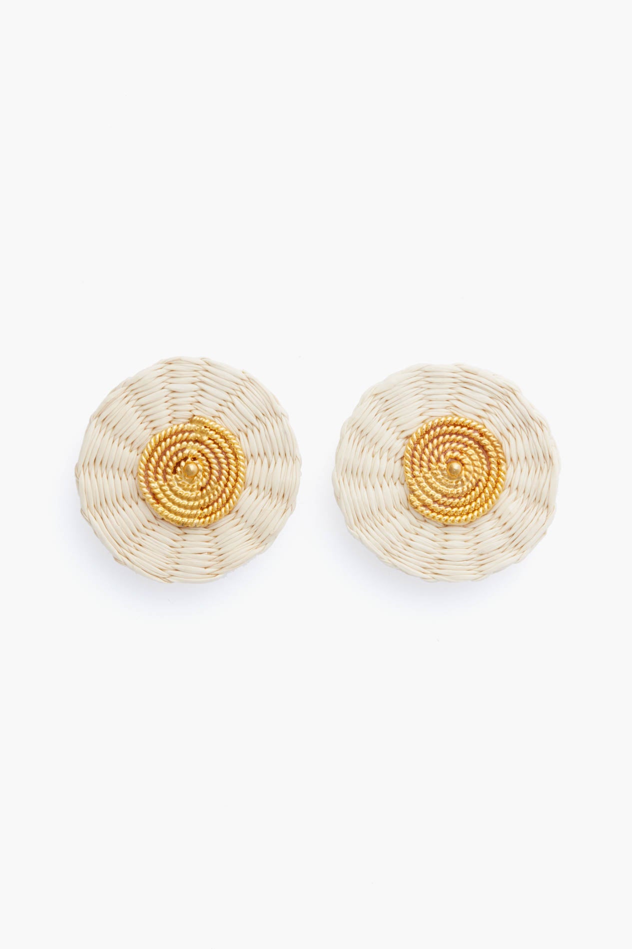 Ana Carolina Valencia presents handmade round woven earrings in beige and gold tones with a concentric pattern, finished with gold-plated studs for a modern jewelry touch.