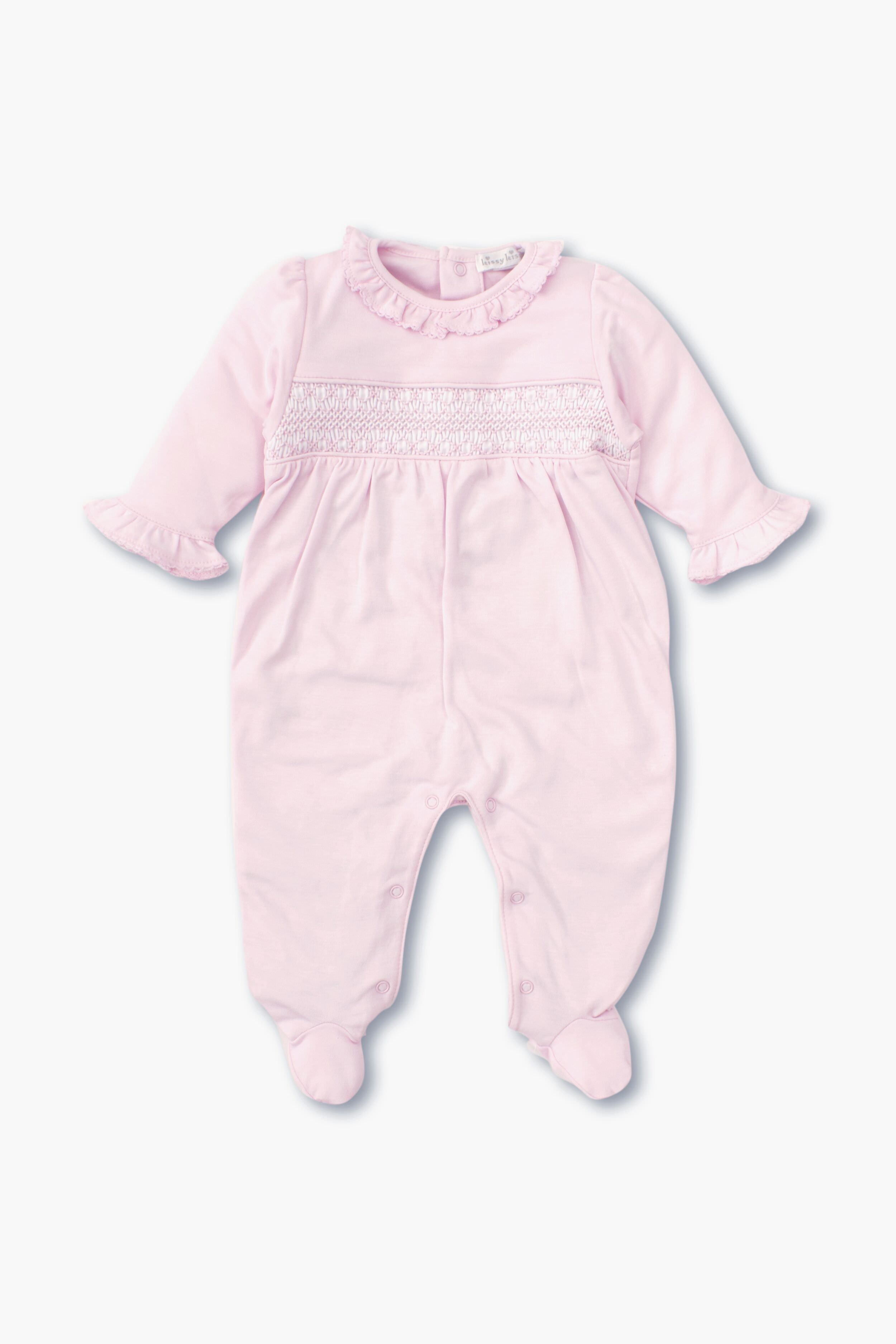 The kissy kissy light pink long-sleeve hand-smocked footie baby onesie is made from soft Peruvian cotton and features a ruffled collar, ruffled cuffs, smocked chest detail, and closed feet.