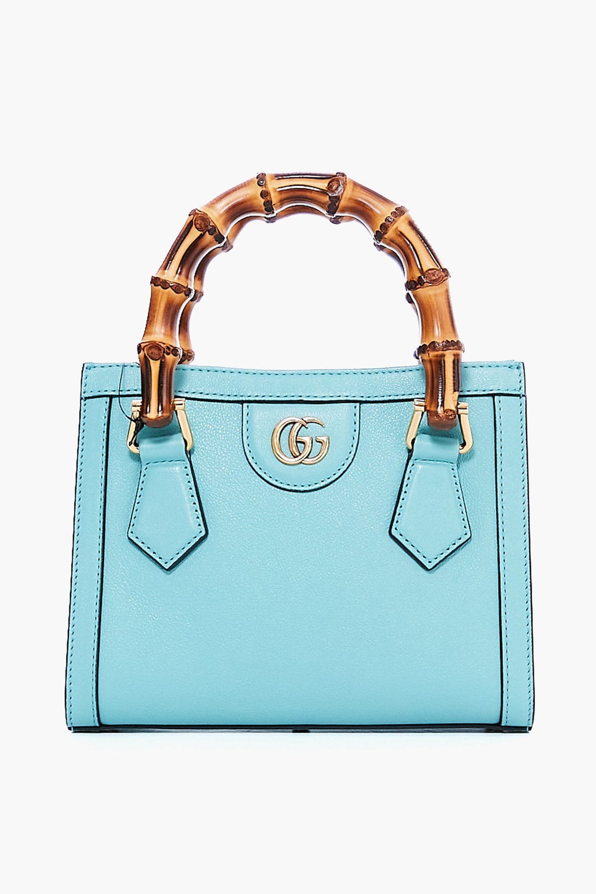 A small Tuckernuck Archive Collection mini tote in light blue leather with gold hardware and a curved bamboo handle, featuring a double G logo on the front.