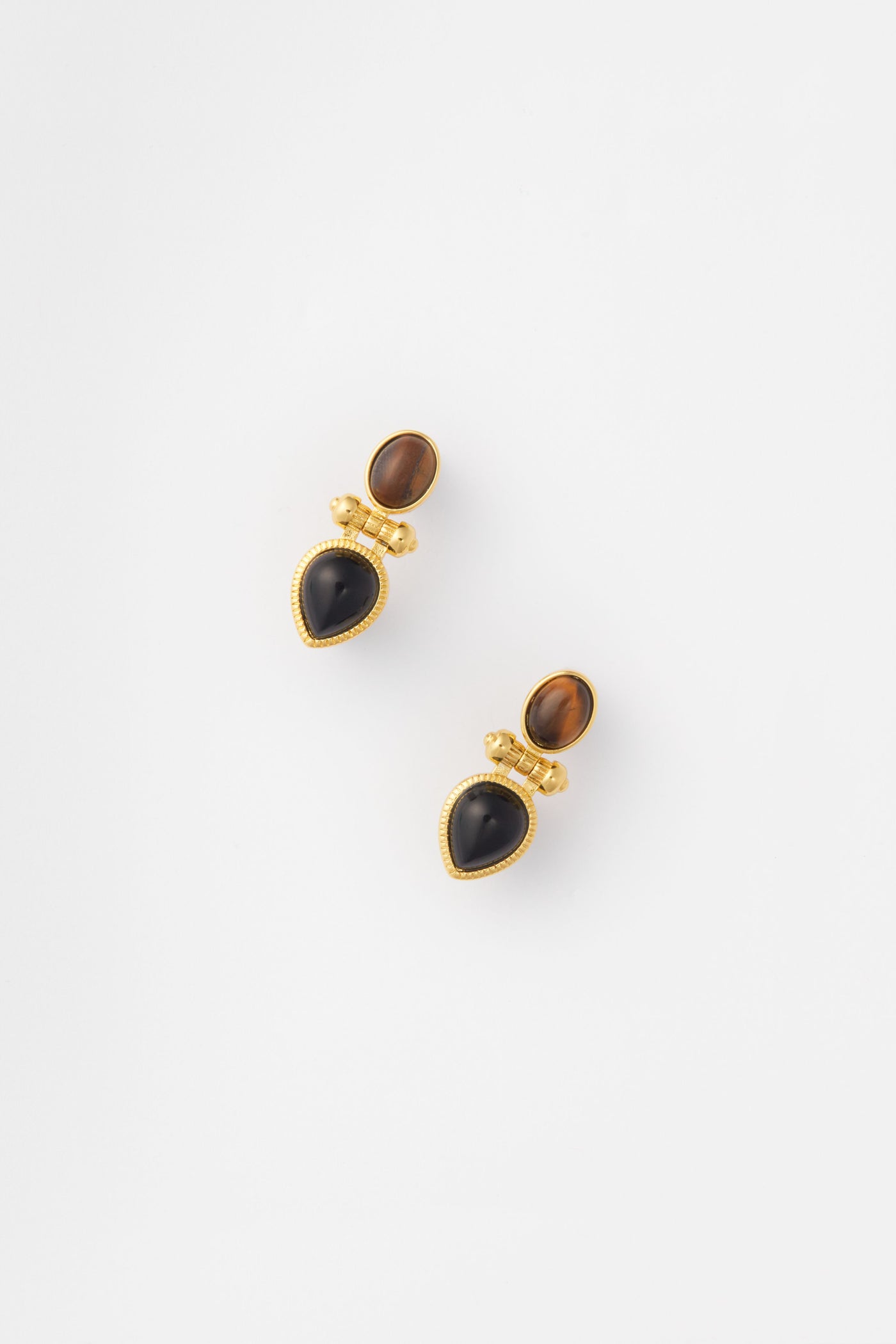 The Petit Moments Gold Rosario Earrings feature gold-trimmed brown ovals and black teardrop stones, making a striking statement.