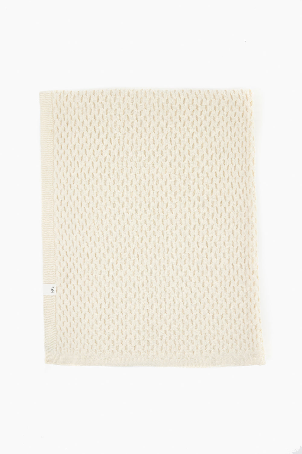 A cream-colored, rectangular knit baby blanket by baa, crafted from Hudson Valley Cormo wool with a textured pattern. This luxury heirloom is sustainably made and neatly folded, perfect for cherished moments.