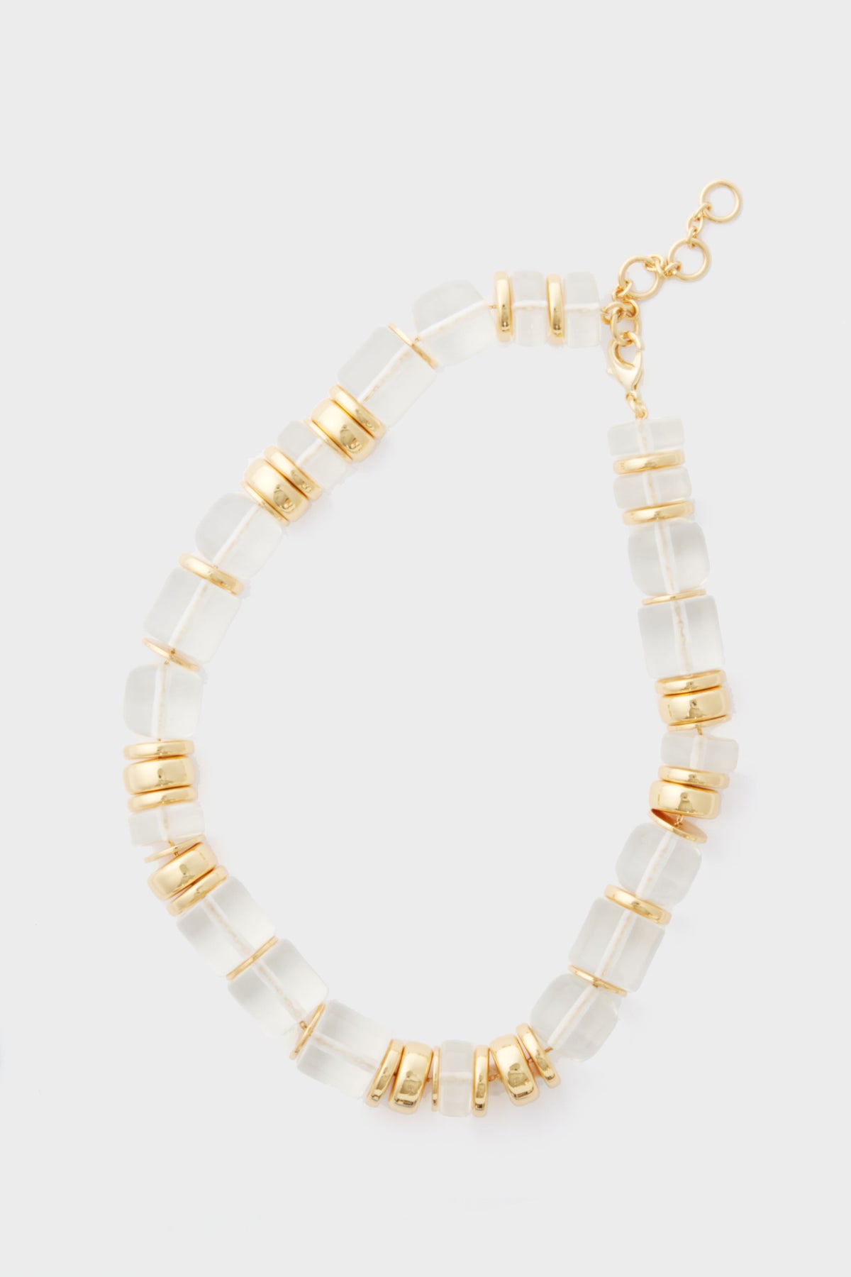 The Sadie Necklace by Tuckernuck Jewelry features translucent rectangular beads, gold round spacers, a gold clasp, and adjustable chain—an elegant statement piece with gold and clear beads for a timeless look.