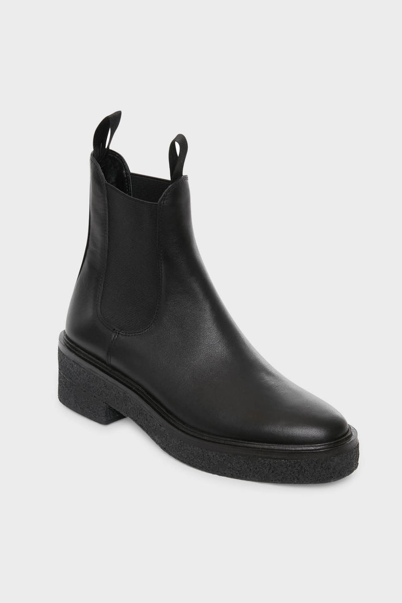 Loeffler Randall’s Black Raquel Boots are black leather Chelsea boots with elastic side panels, front and back pull tabs, and a thick textured sole—offering a modern update on classic platform-heel styles.