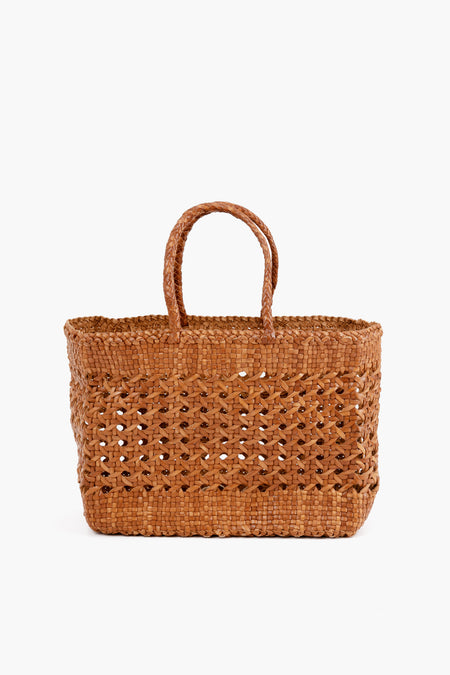 Dragon Diffusion presents a rectangular handmade tote crafted from woven straw, featuring two handles and showcasing thoughtful craftsmanship.