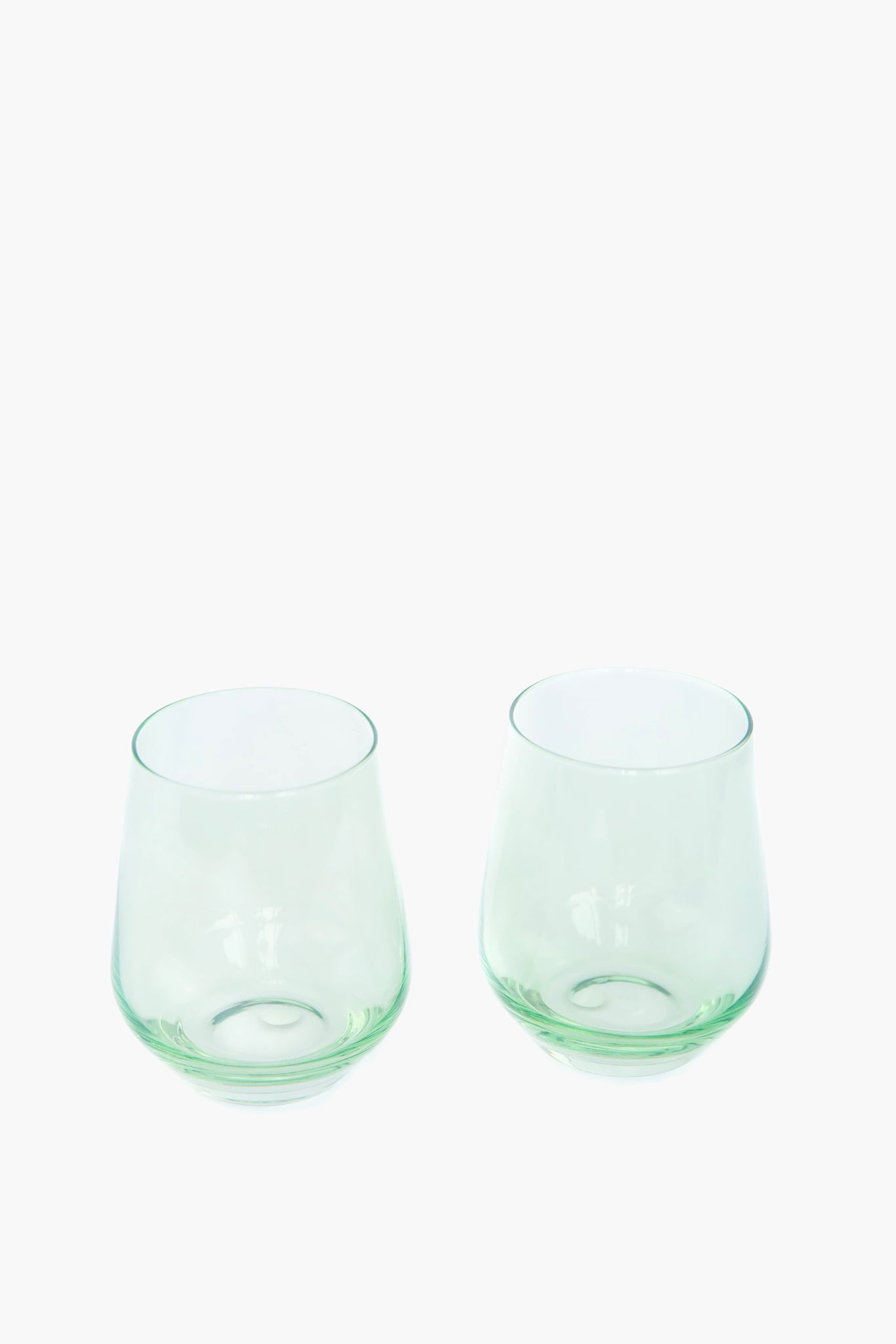 Mint Stemless Wine Glasses Set of 6, featuring classic, slightly green-tinted hand-blown glass. Their effortless, high-end design adds a fun, chic touch to any table.