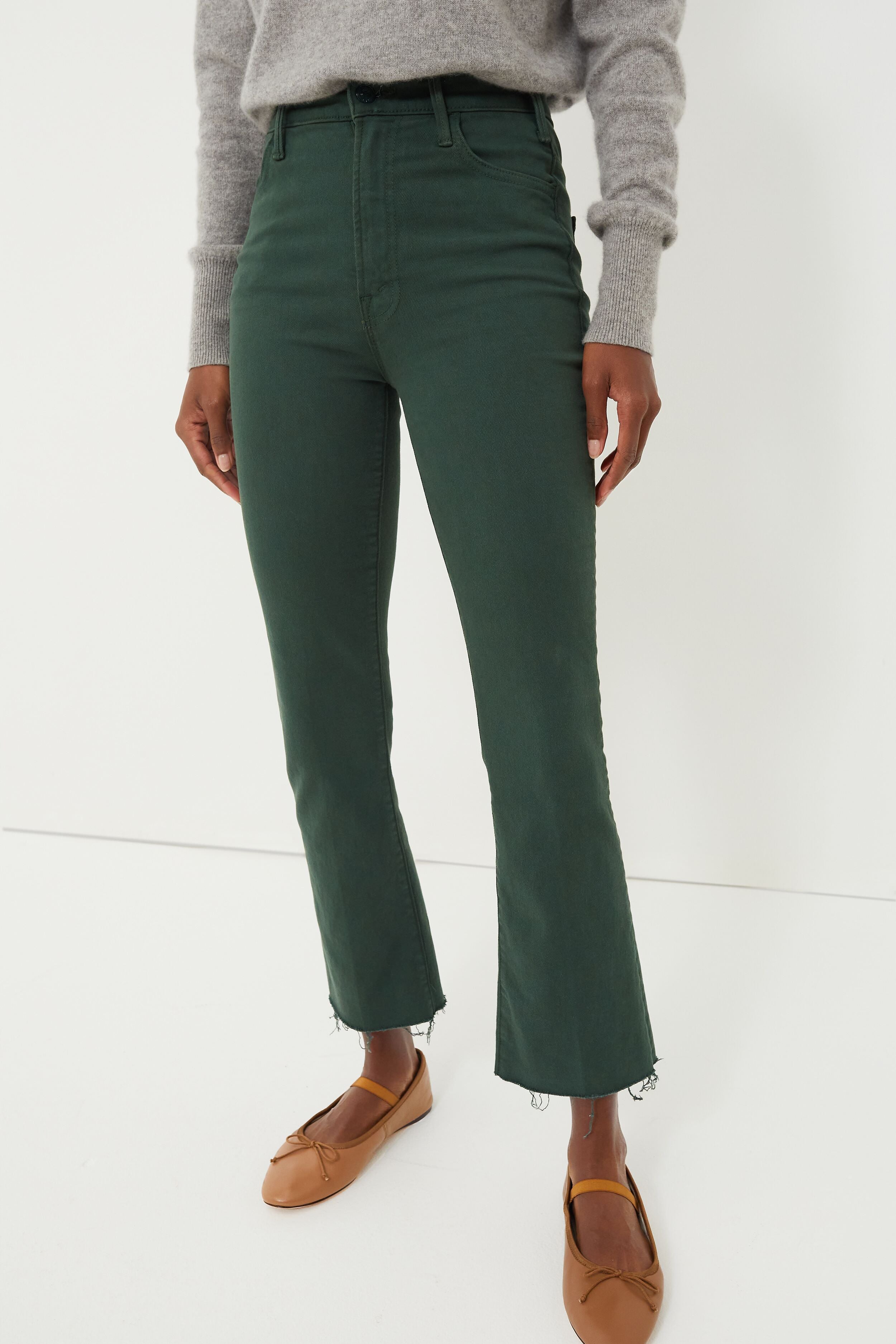 Person wearing a gray sweater, high rise ankle length green kick flare jeans with frayed hems from MOTHER, and tan ballet flats.