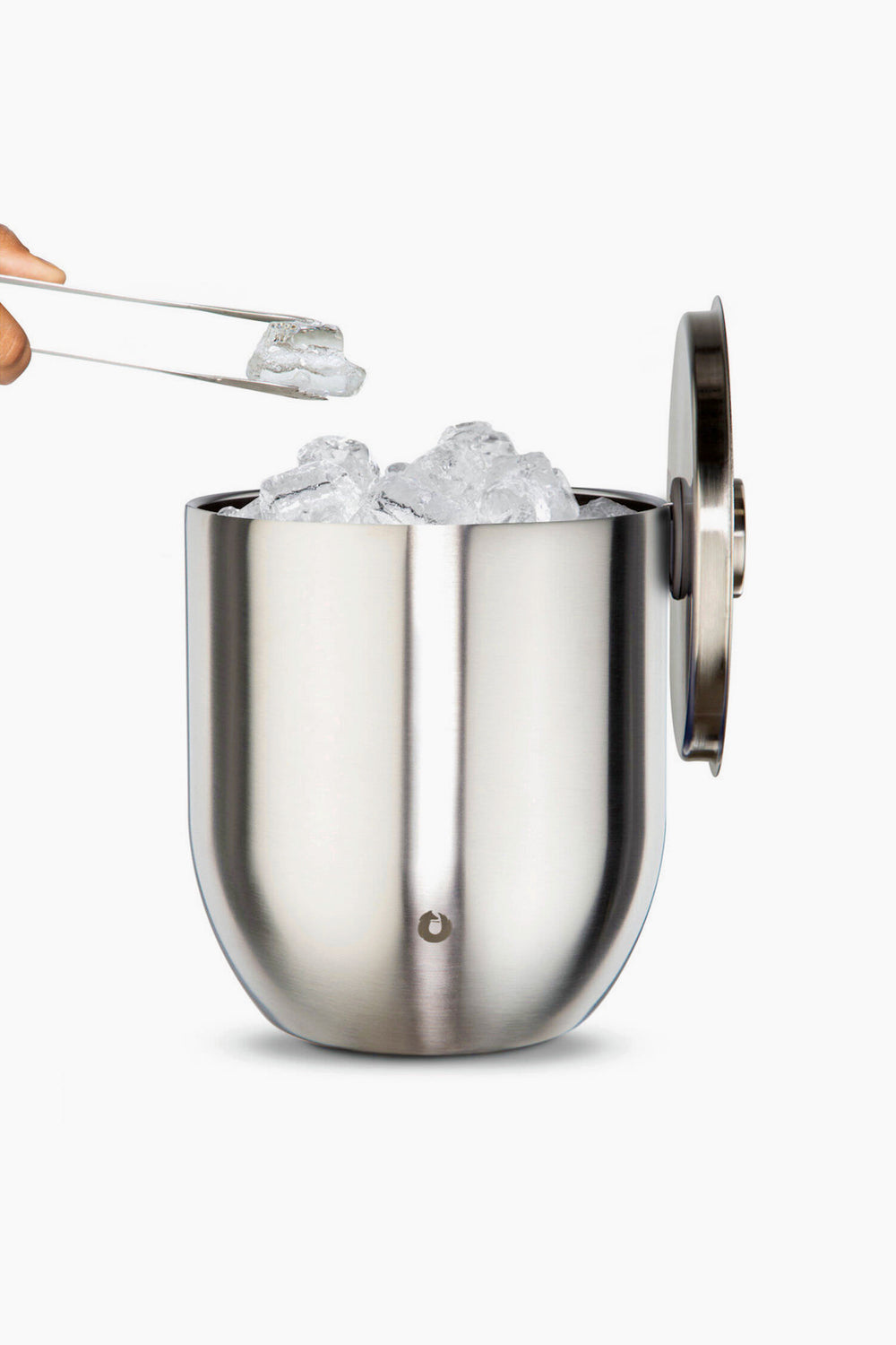 A Snowfox double-walled stainless steel ice bucket filled with ice cubes sits open, as tongs lift an ice cube above the insulated barware container.