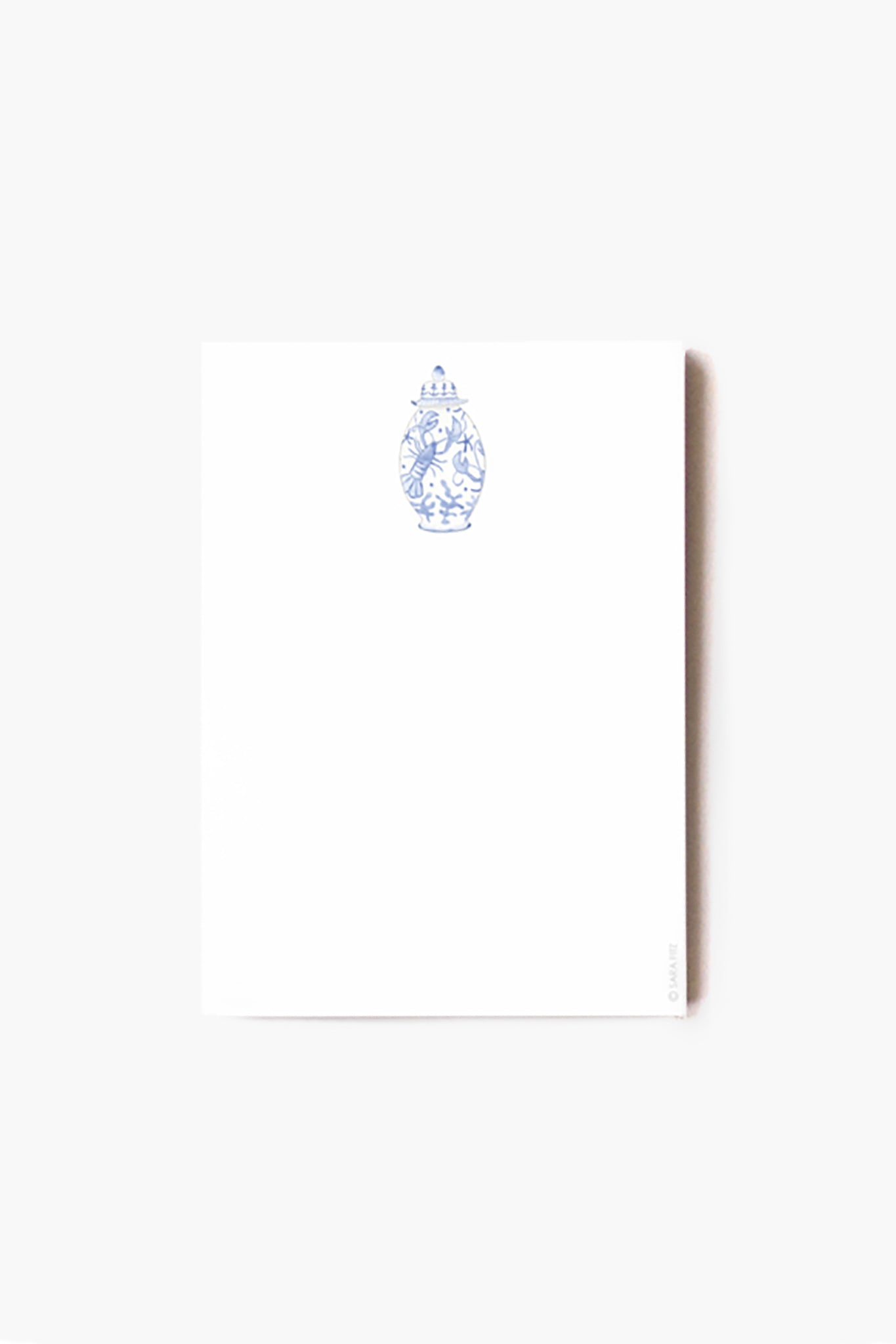 A white illustrated notepad by Sara Fitz featuring a small blue decorative vase design near the top, perfect as a coastal desk accessory or Nautical Ginger Jar Notepad.