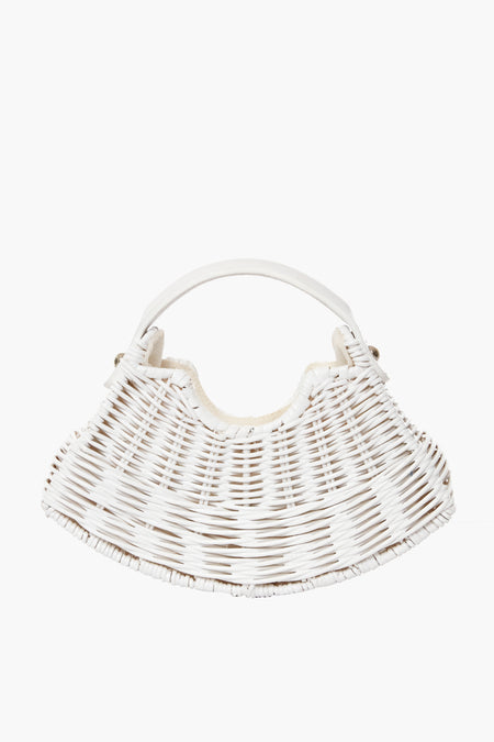The Wicker Wings white woven wicker handbag features a curved shape and top handle. Handmade from rattan, it’s an ideal choice for sustainable fashion lovers.