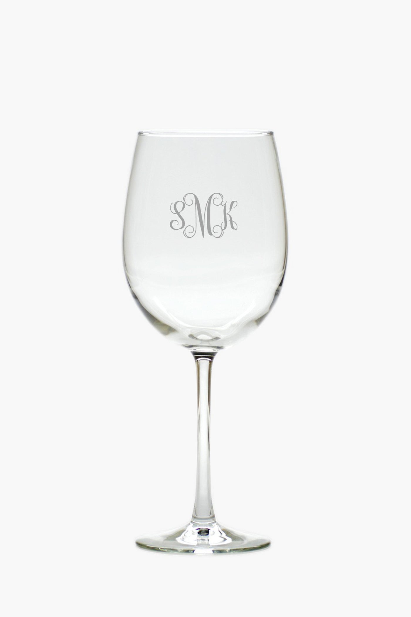A clear tulip glass from Carved Solutions, engraved with the monogram SMK on its bowl, offers elegant personalized glassware.
