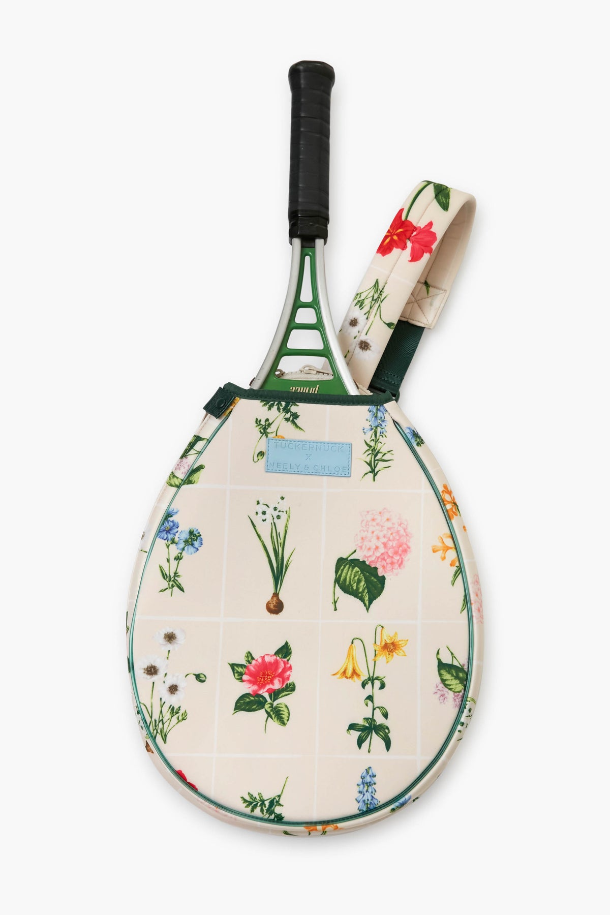 A Tnuck Sport x Neely & Chloe tennis racket with a black grip in a floral-patterned neoprene bag adorned with colorful flowers and a matching strap.
