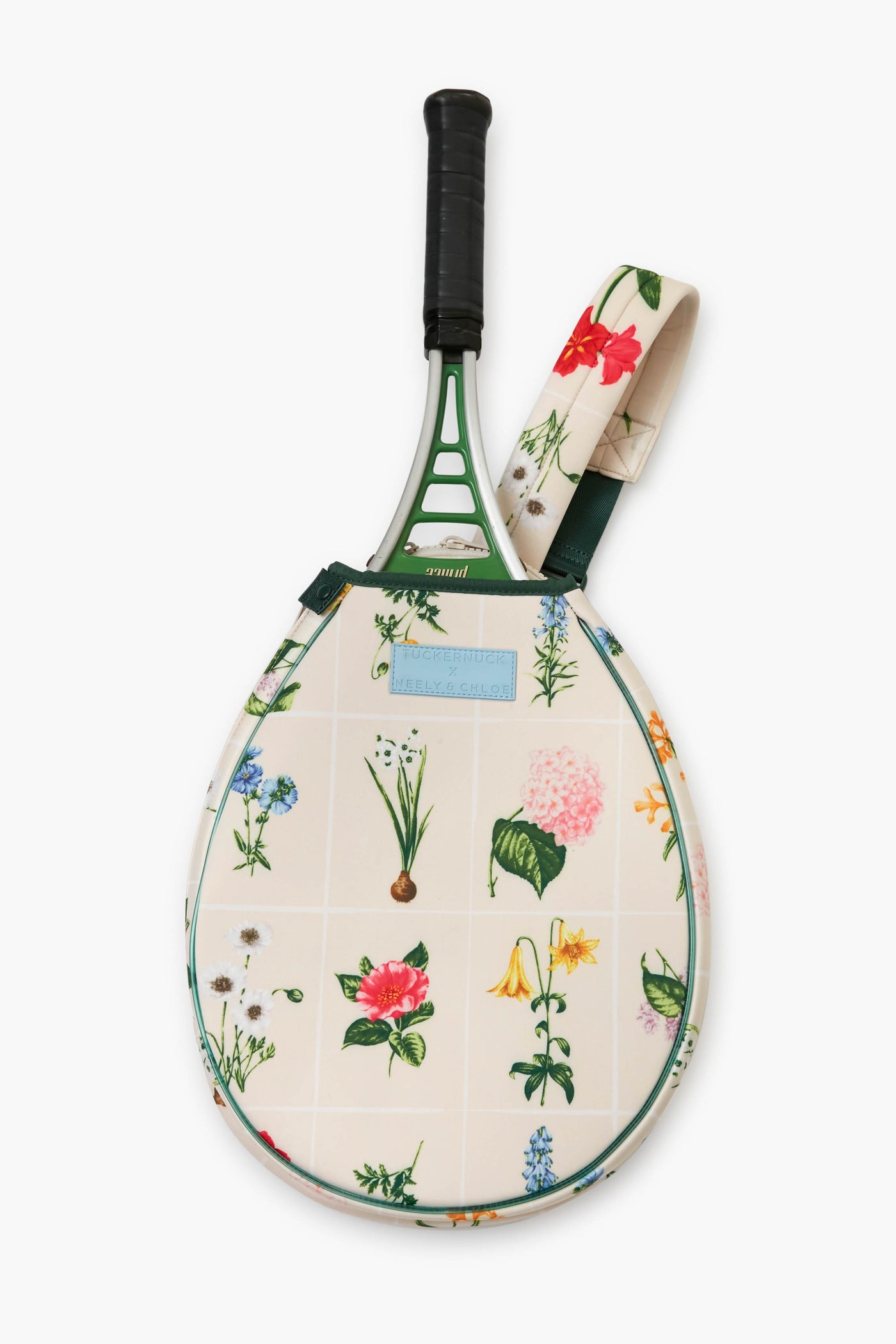 A Tnuck Sport x Neely & Chloe tennis racket with a black grip in a floral-patterned neoprene bag adorned with colorful flowers and a matching strap.
