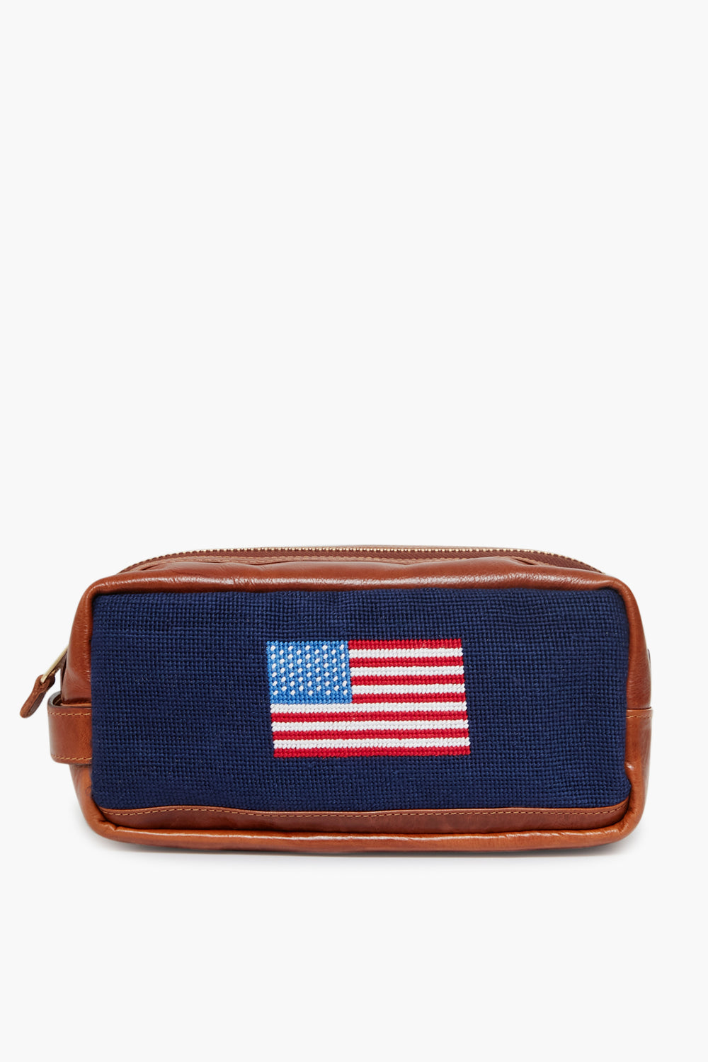 The Smathers and Branson Navy American Flag Needlepoint Toiletry Bag is crafted from Italian leather, with hand-stitched needlepoint and an embroidered American flag on the front.