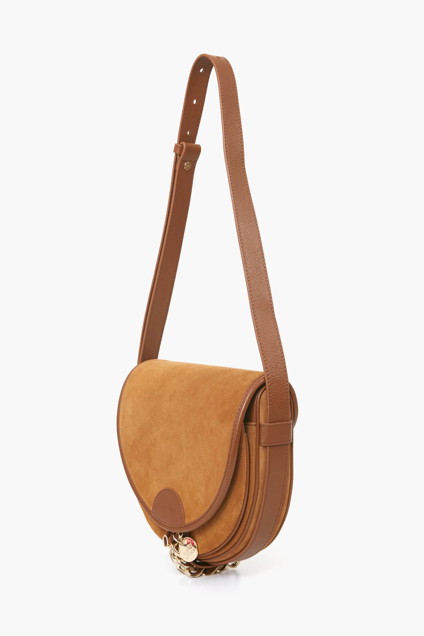 The See by Chloe Mara Bag is a tan cowhide leather and suede crossbody saddle bag featuring a flap closure, gold hardware, and an adjustable strap—blending timeless style with modern luxury.