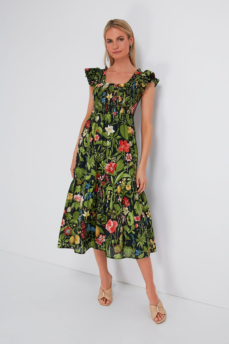 Woman in a Tuckernuck sleeveless, ankle-length Mallie Dress with a colorful floral print and beige open-toe heels—a perfect spring maxi dress.