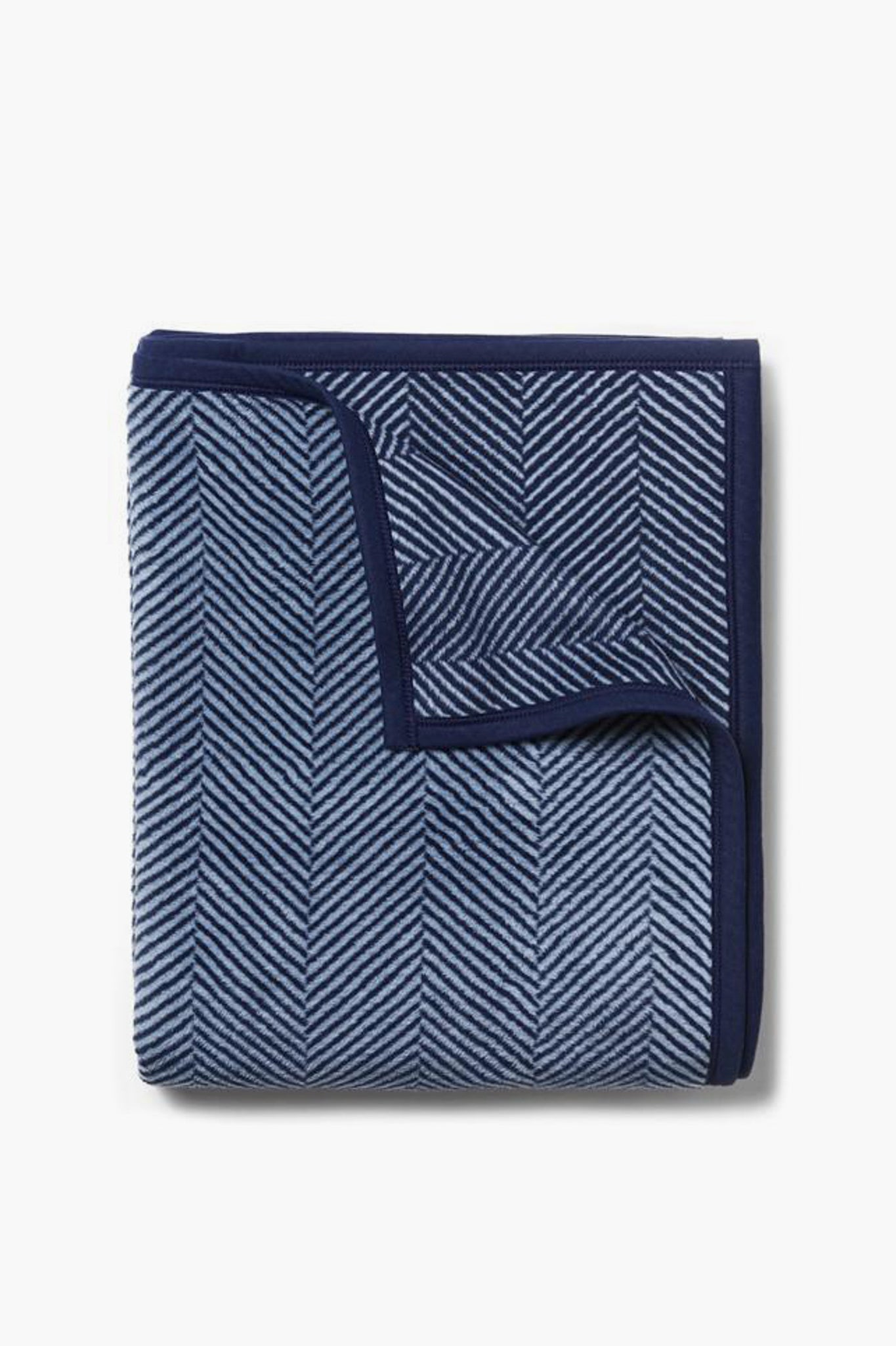 A machine-washable ChappyWrap blanket, neatly folded in a blue and navy herringbone pattern with a solid navy border.