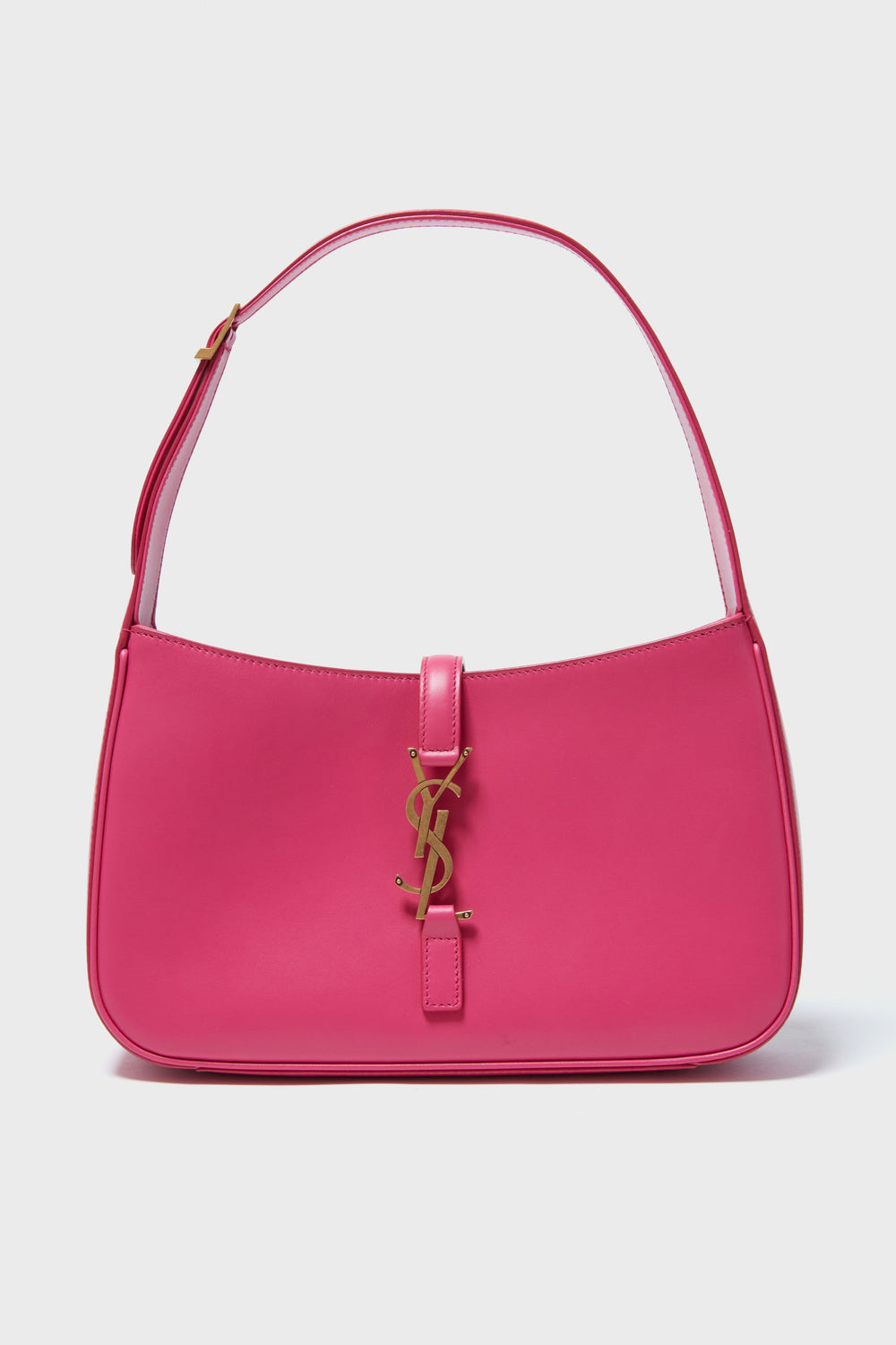 A pink Tuckernuck Archive Collection hobo bag with a gold logo on the front and a single strap, showcasing classic vintage designer handbag style.