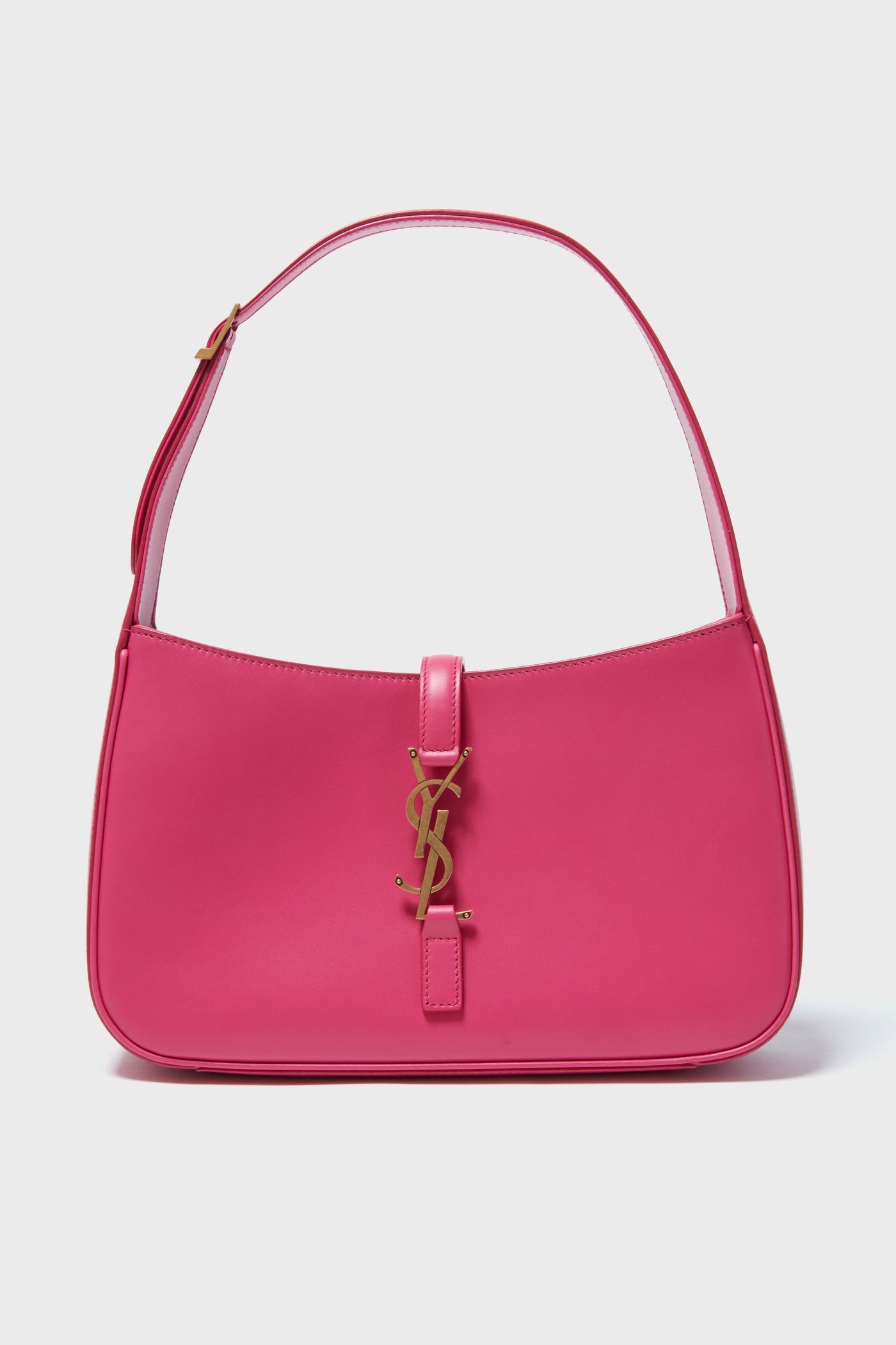 A pink Tuckernuck Archive Collection hobo bag with a gold logo on the front and a single strap, showcasing classic vintage designer handbag style.
