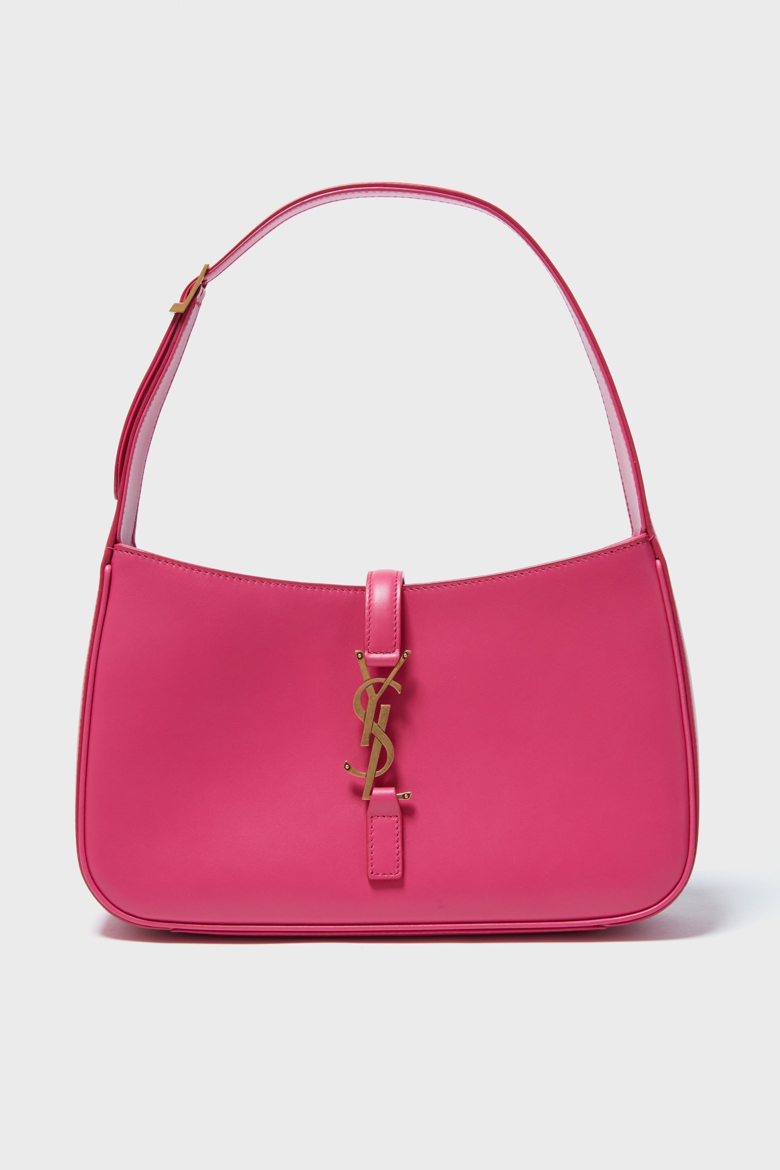 A pink Tuckernuck Archive Collection hobo bag with a gold logo on the front and a single strap, showcasing classic vintage designer handbag style.