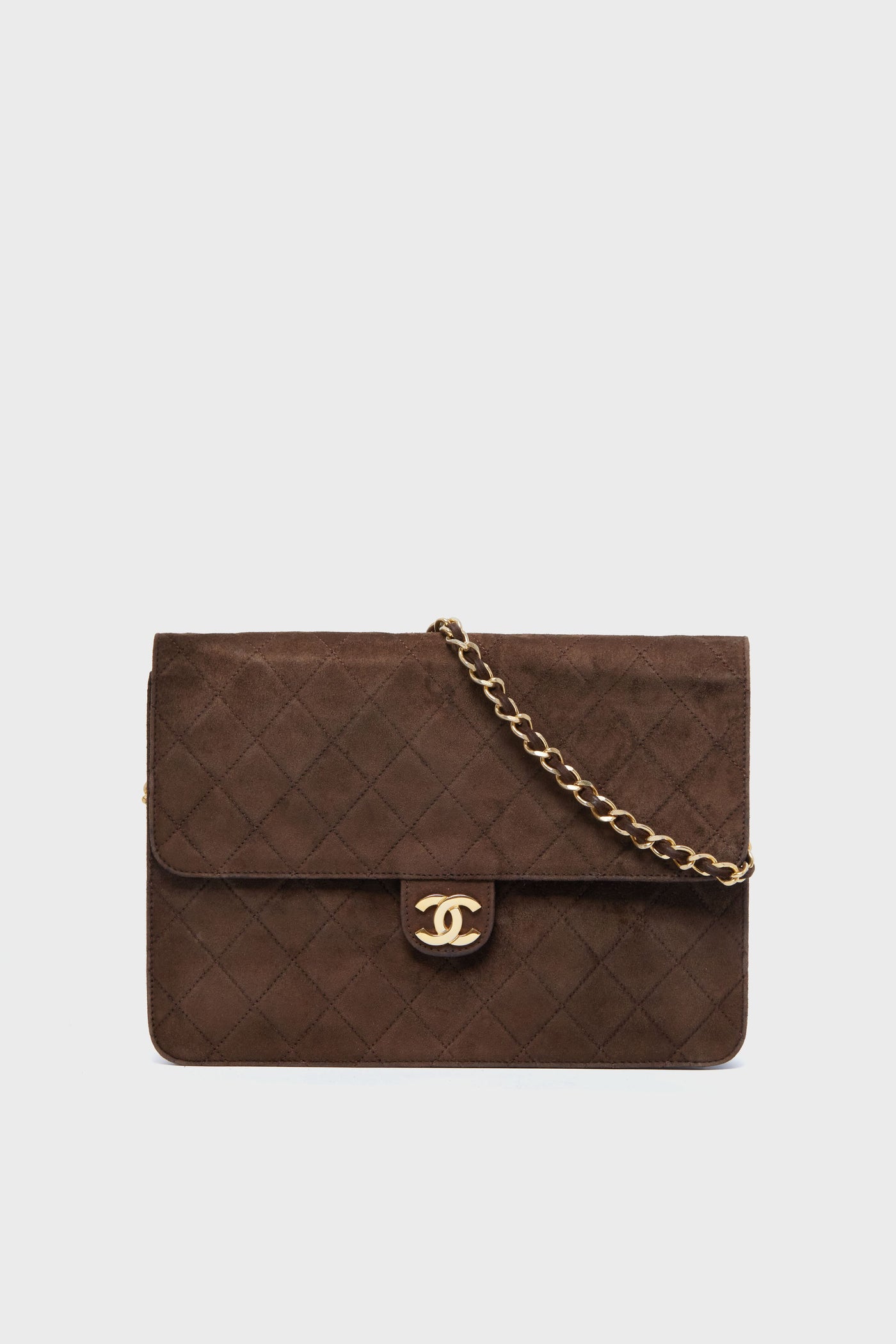 Rectangular brown Tuckernuck Archive Collection bag featuring diamond-quilted suede, a gold chain strap, and a gold logo clasp on the front flap.