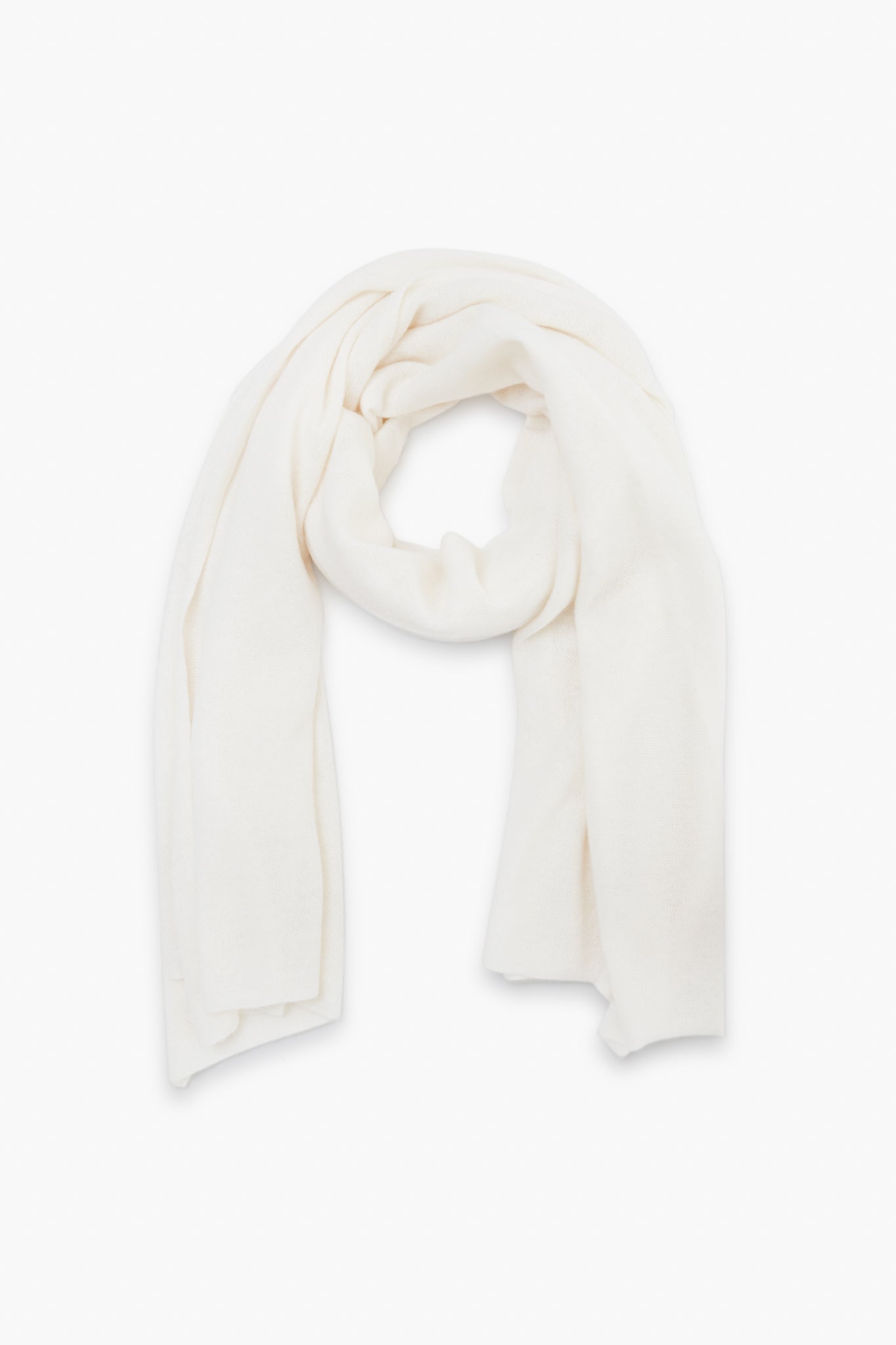 A soft, plain white cashmere travel wrap from White + Warren is neatly arranged in a loop.