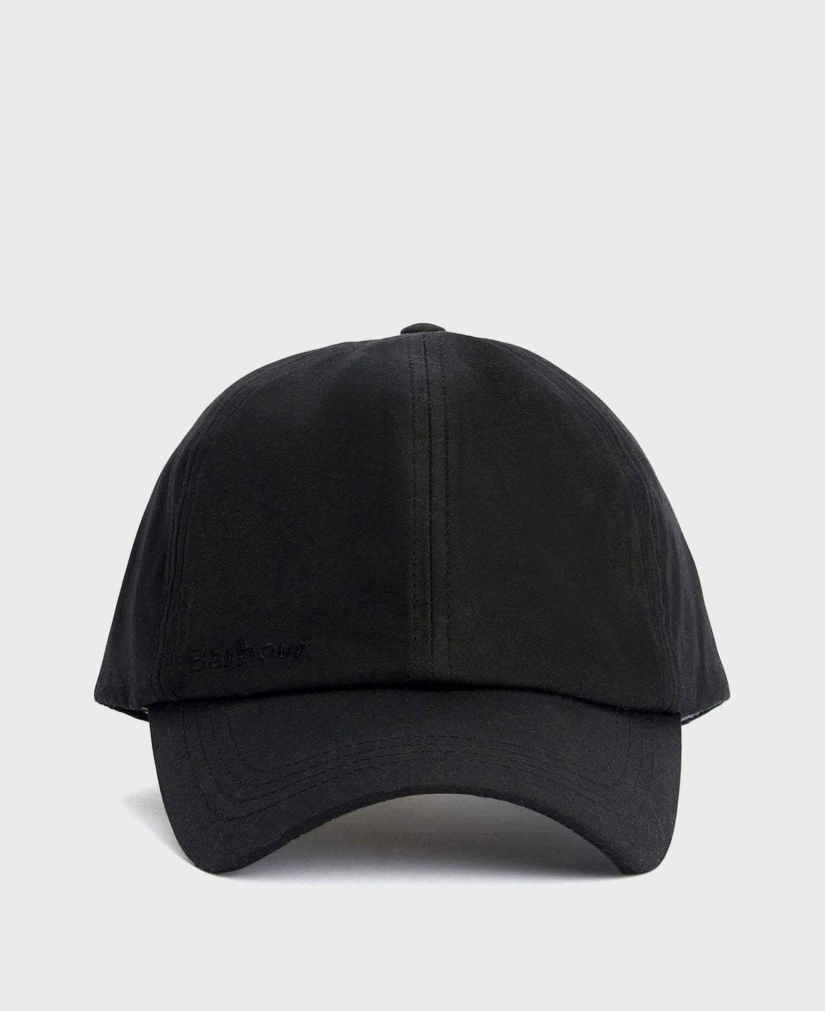 A Barbour black waxed cotton cap with a timeless look and water-resistant finish is displayed in a neutral, minimal setting.