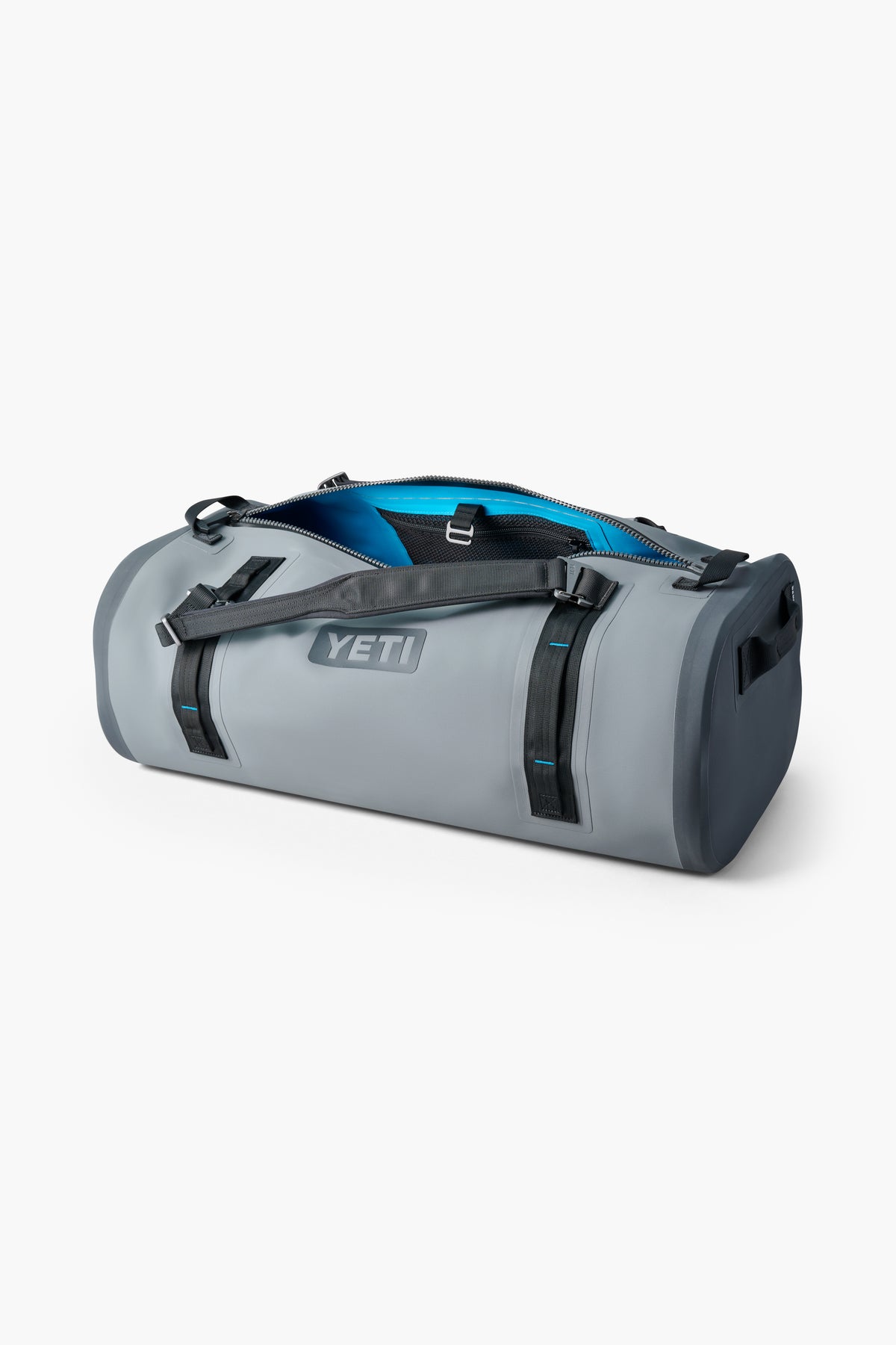 A gray YETI duffel bag with black straps and a partially open zipper reveals a blue interior, making it ideal for carrying outdoor gear or using as a waterproof bag.