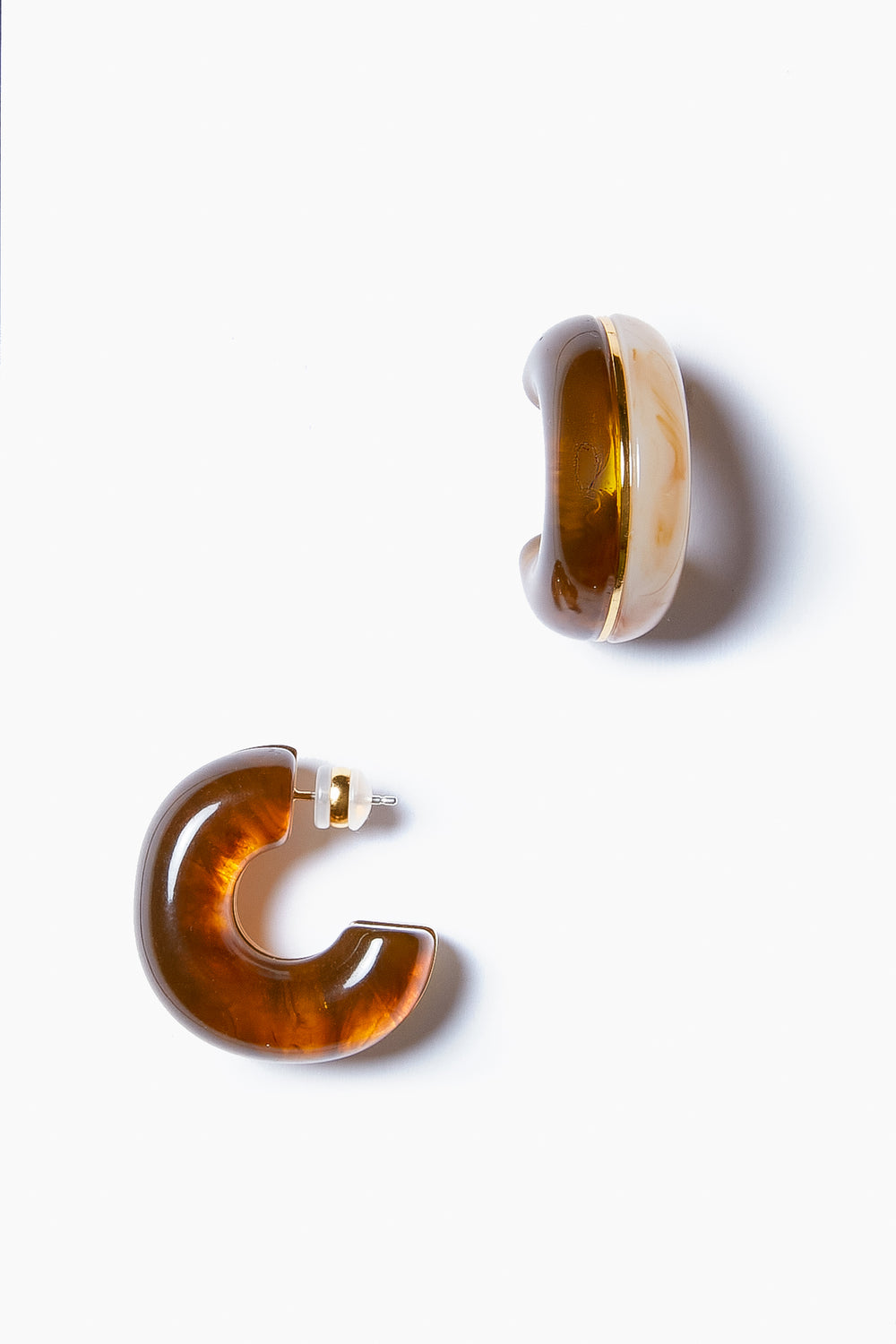 A pair of brown, translucent resin halo hoop earrings with a chunky design and gold-plated brass accents from Lizzie Fortunato.