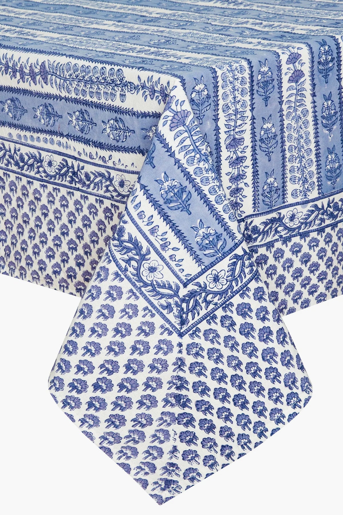 A rectangular table adorned with a blue and white Couleur Nature Paris French tablecloth, featuring handmade linen and botanical designs.