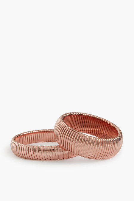 Two rose gold ribbed metal bangles by Ben Amun, crafted from gold-plated brass, are stacked together for a bold statement jewelry piece.