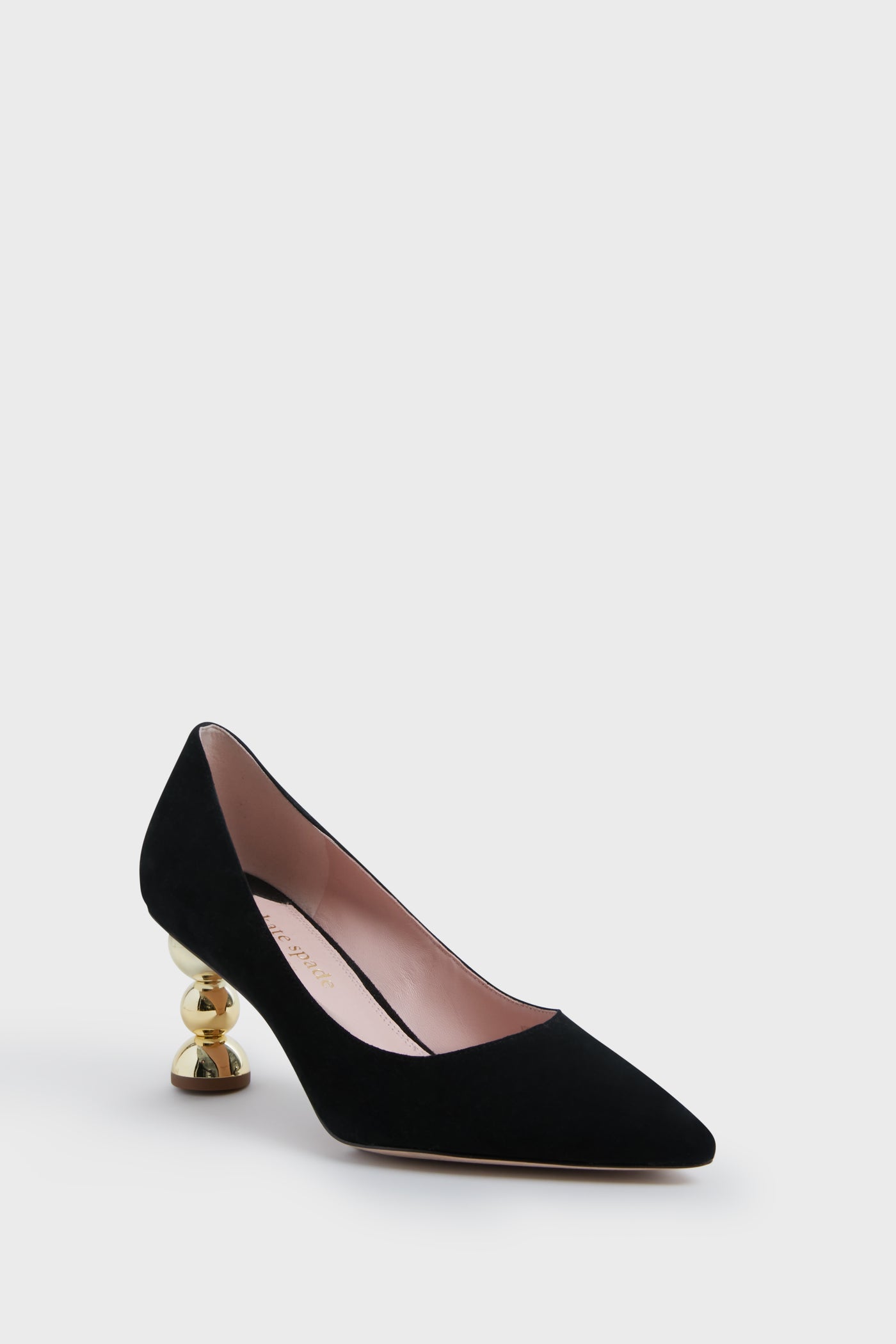 A chic black suede pointed-toe pump by Kate Spade New York features a low gold stacked heel and pink inner lining—perfect for stylish footwear lovers.