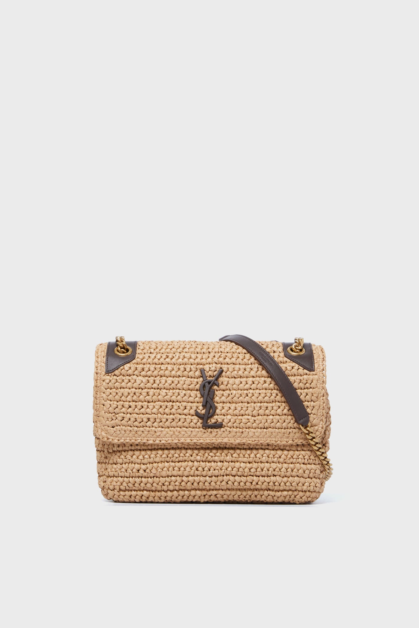 A tan woven Tuckernuck Archive Collection Chain Bag with a flap closure, gold hardware, black leather accents, and a signature logo on the front—an iconic designer crossbody bag.