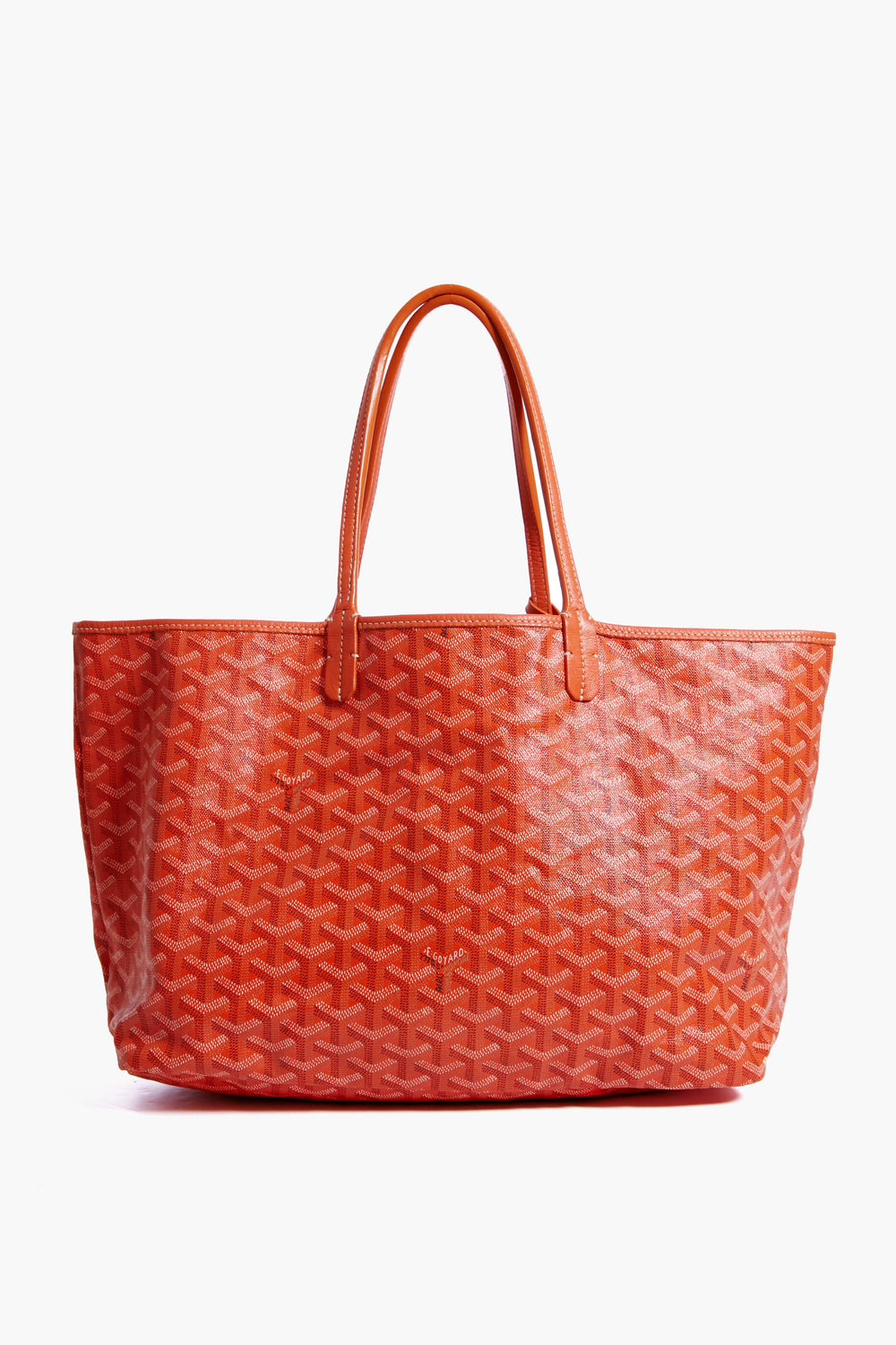 A spacious orange tote from the Tuckernuck Archive Collection, crafted with textured patterned canvas and two handles, inspired by the iconic Saint Louis Tote.