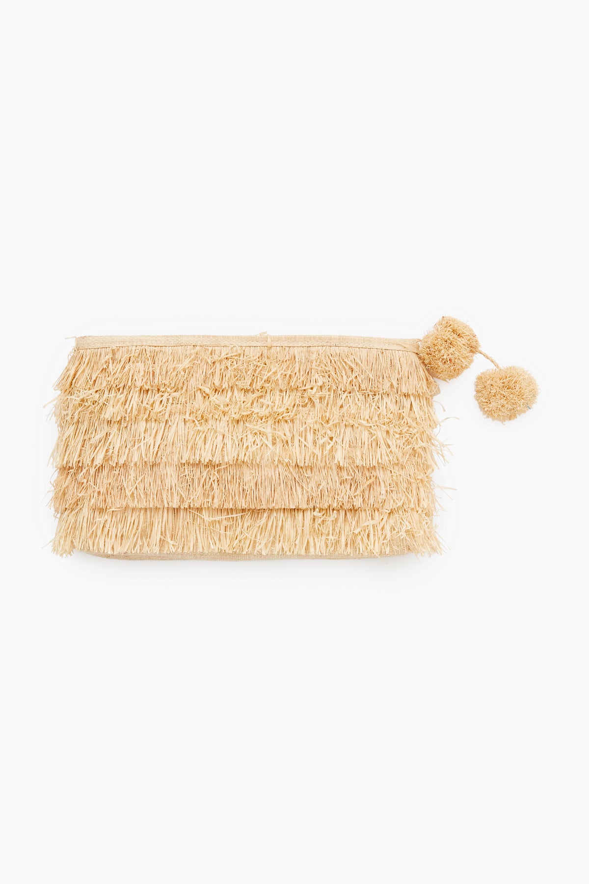 The Mar y Sol beige raffia clutch is handcrafted in Madagascar with sustainable materials, featuring layered fringes and two playful pom-poms on the zipper.