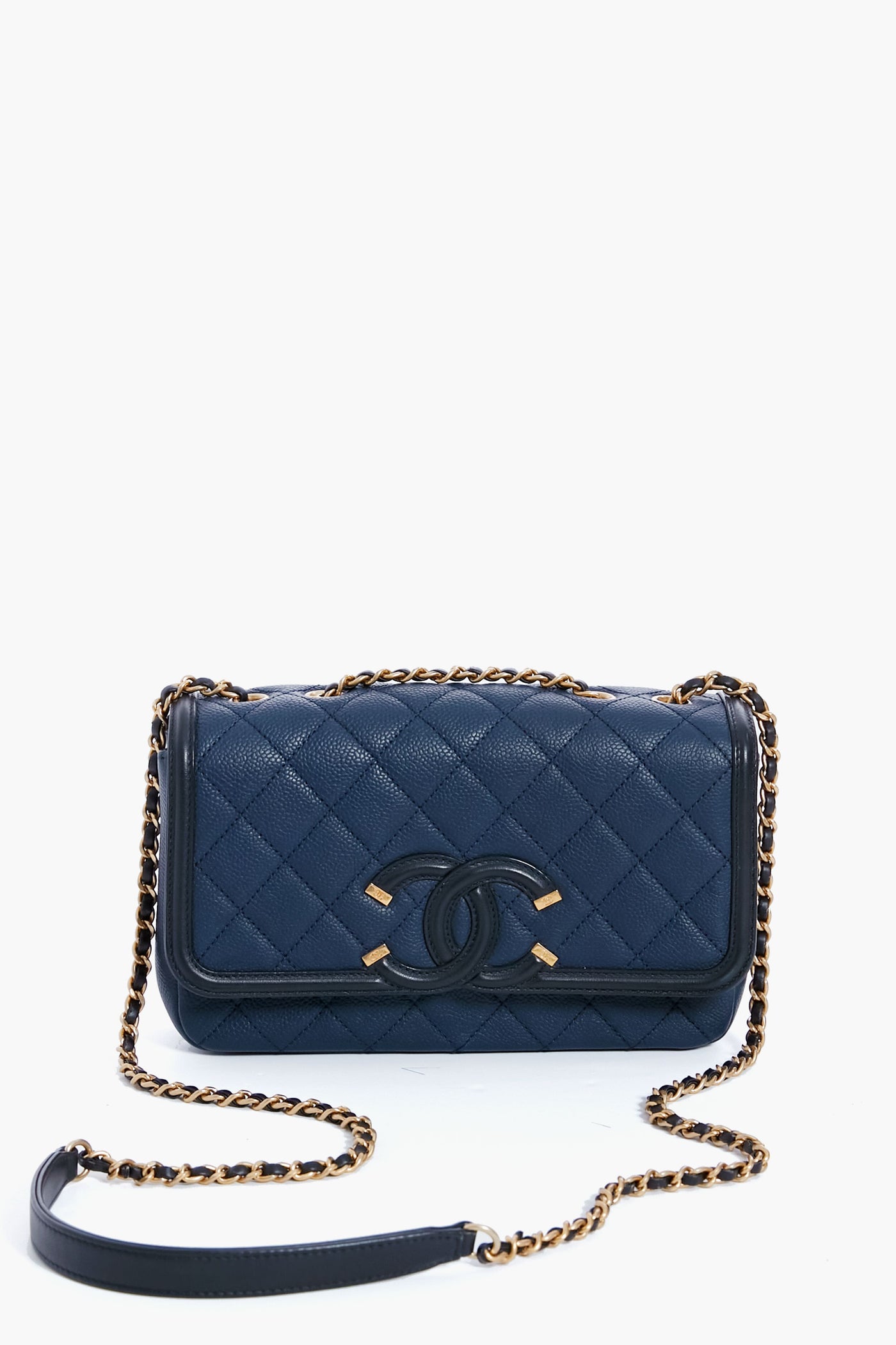 A navy blue Tuckernuck Archive Collection Classic Flap Bag in quilted leather, featuring a chain strap and interlocking logo on the front.