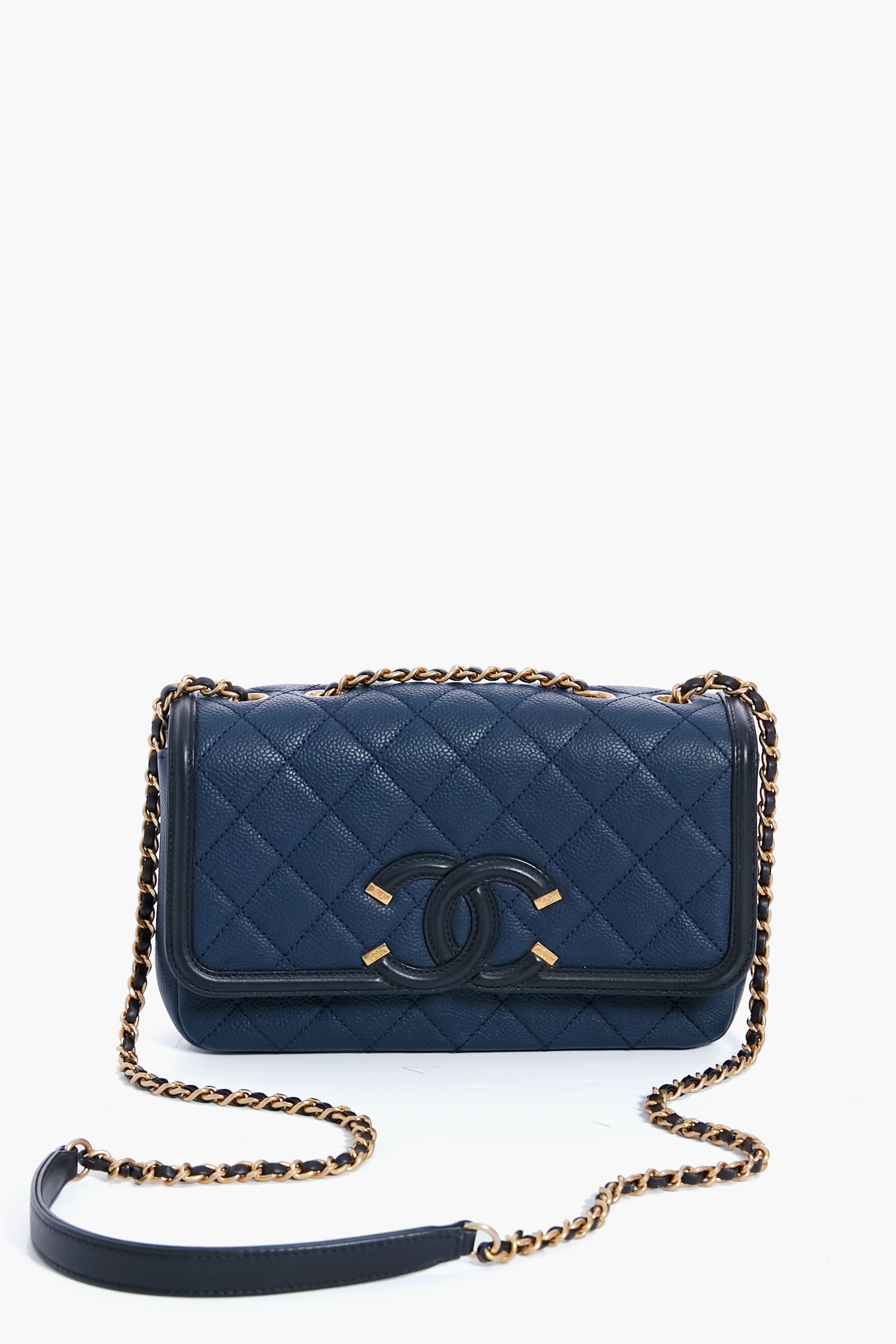 A navy blue Tuckernuck Archive Collection Classic Flap Bag in quilted leather, featuring a chain strap and interlocking logo on the front.
