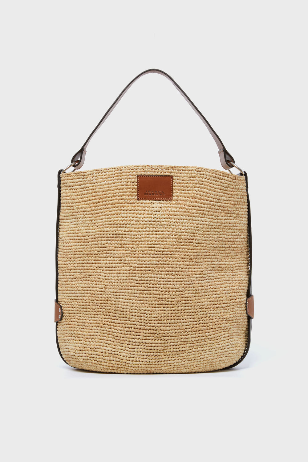 Isabel Marant beige woven raffia bag featuring brown leather trim, a leather top handle, and a rectangular leather patch on the front.