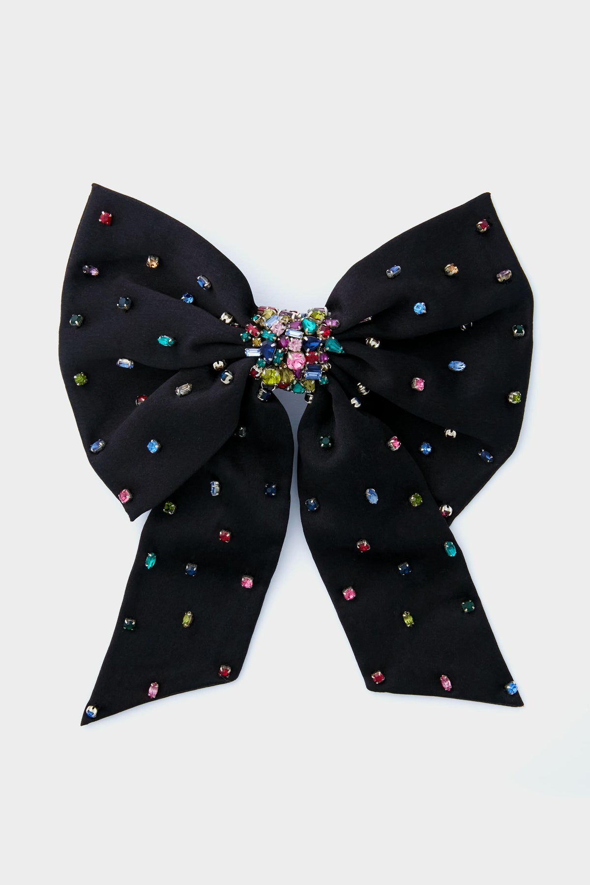 The Mignonne Gavigan Black Grace Bow Hairclip features a large black fabric bow adorned with multicolored gem accents and a central cluster of vibrant gems, adding an elegant touch to any hairstyle.