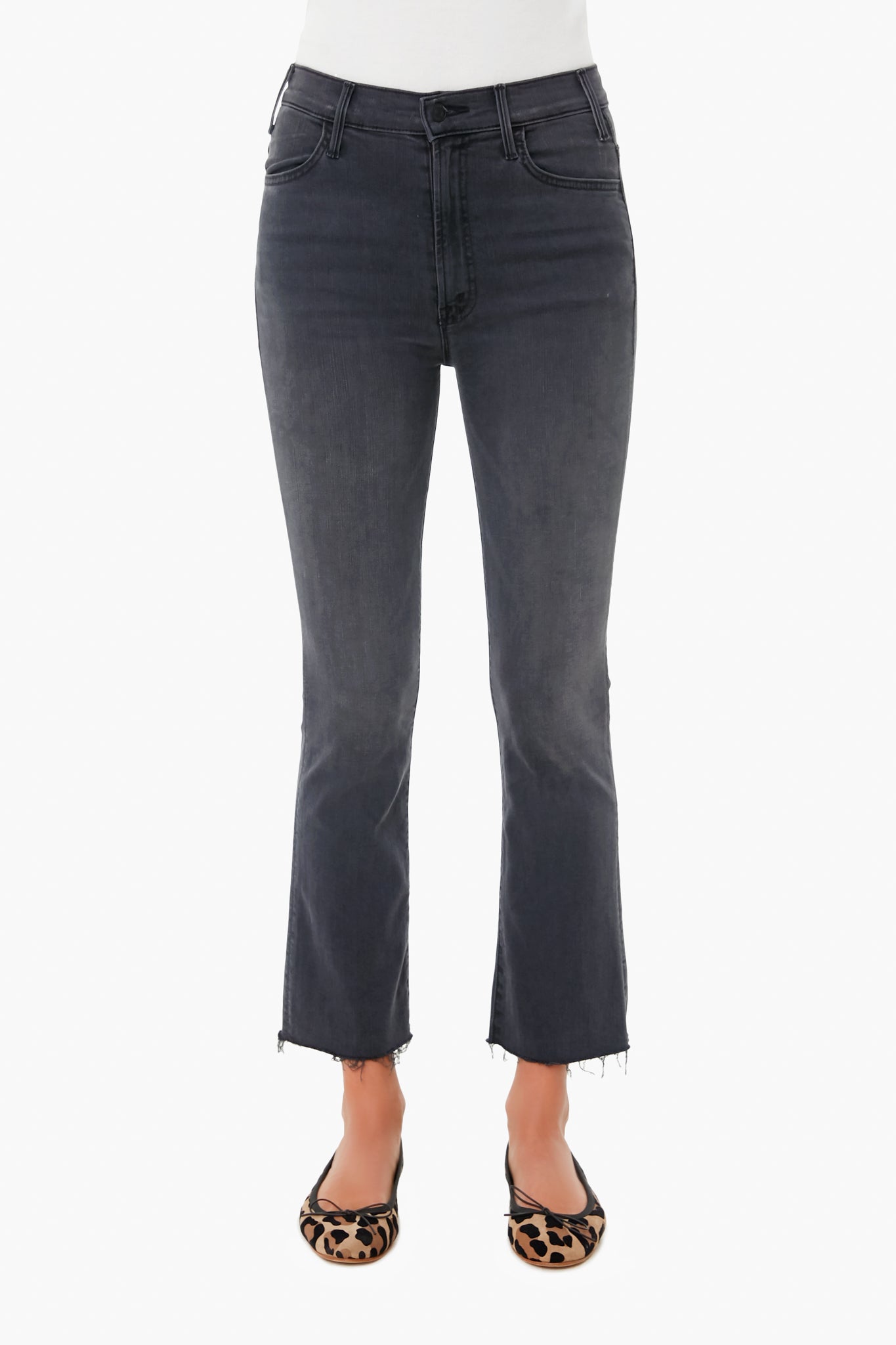 A person is shown from the waist down wearing MOTHER high-waisted, dark gray straight-leg jeans with raw hems and leopard-print flats.
